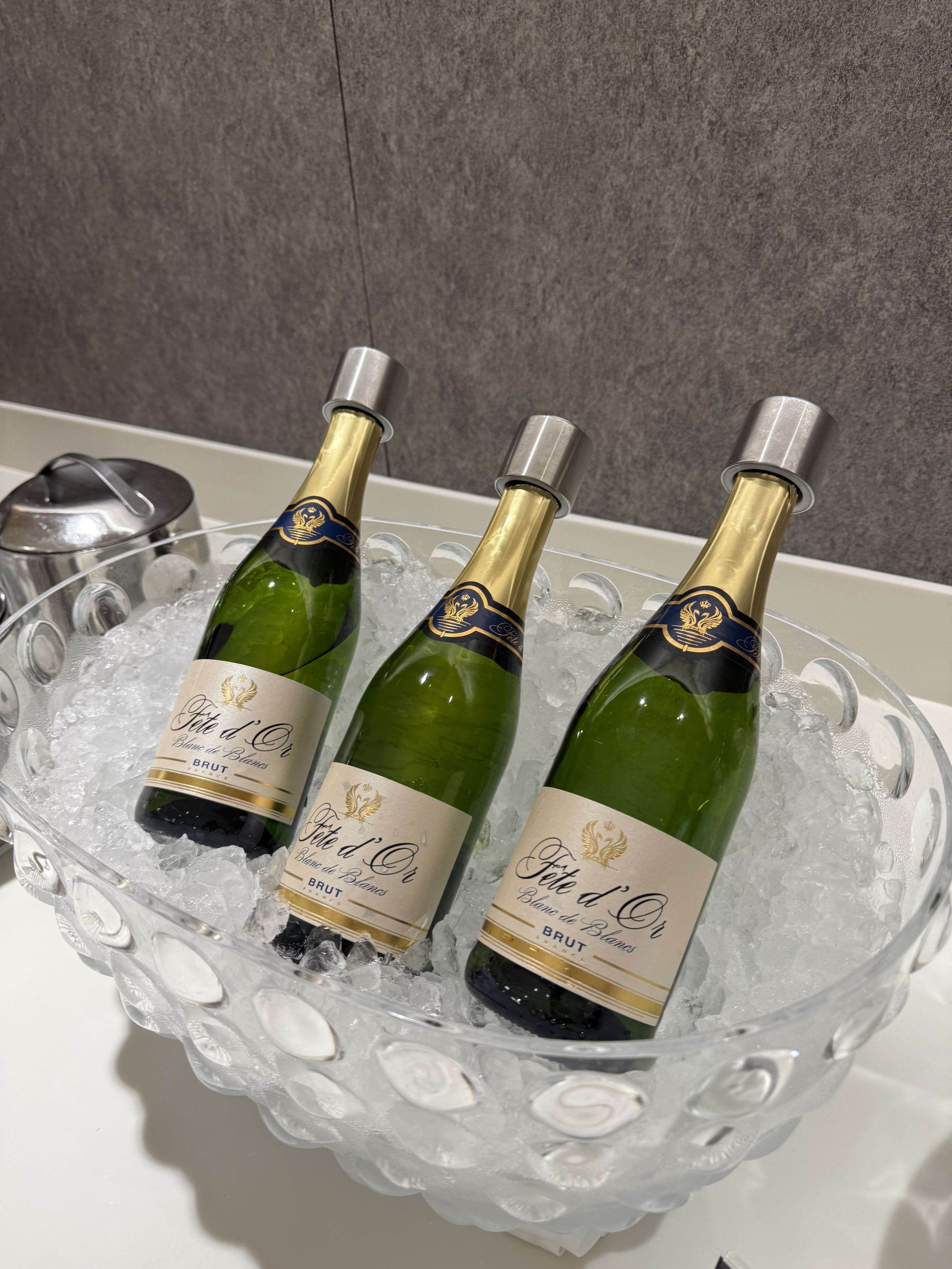 氷入りガラスボウルで冷やされる3本のスパークリングワイン。