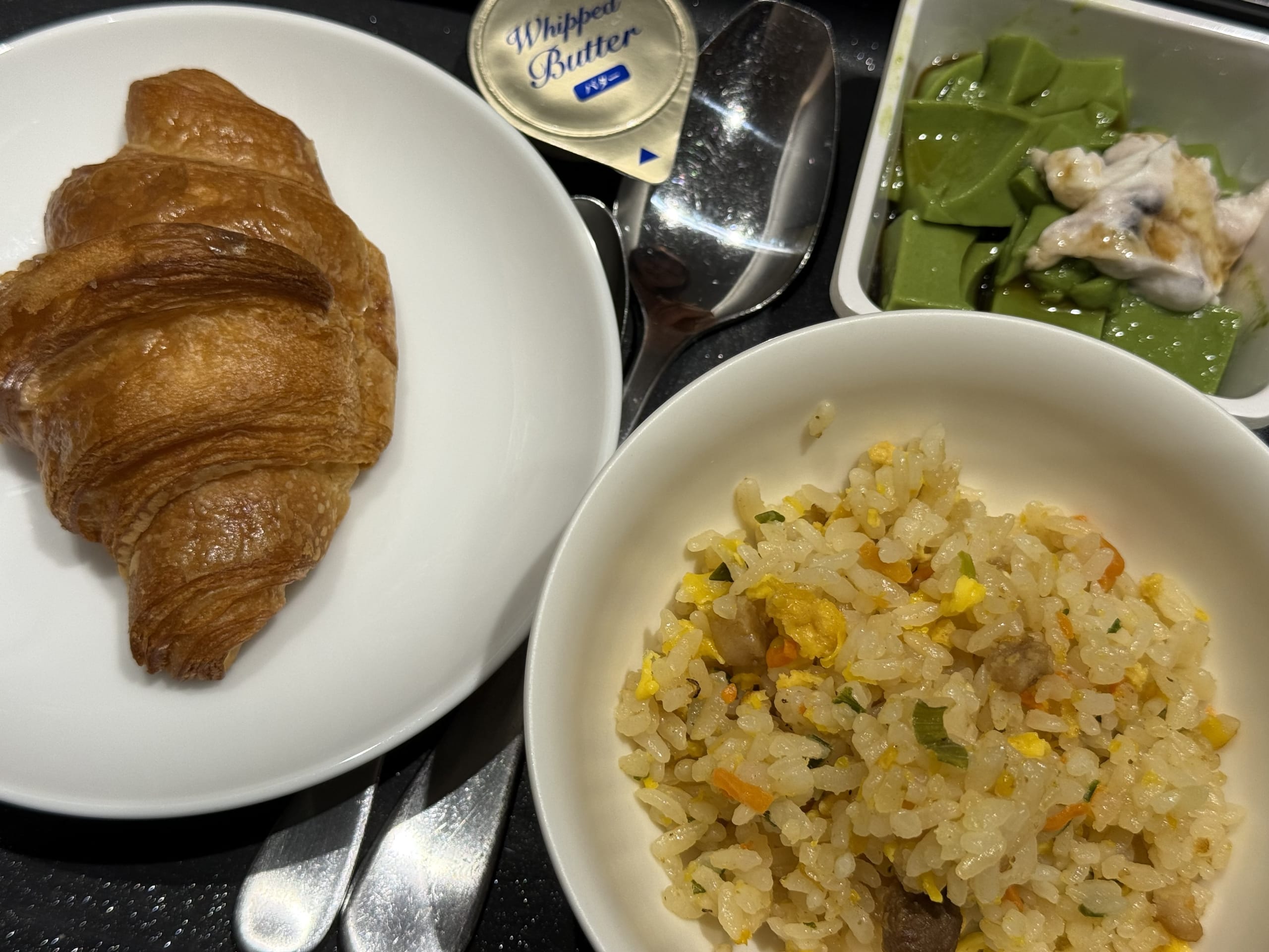 クロワッサンとチャーハンが並ぶ機内食。