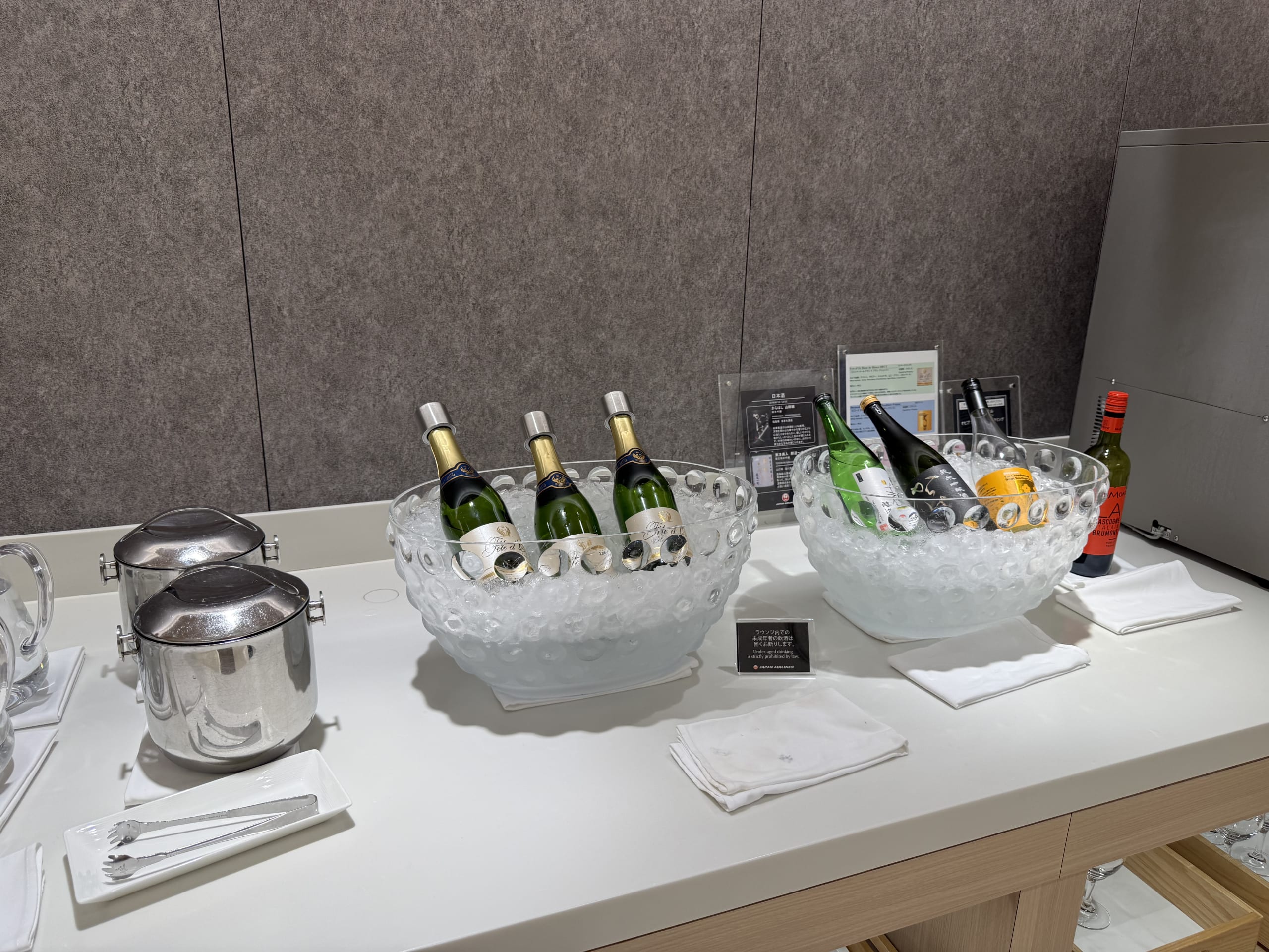 ラウンジで氷入りのボウルに冷やされた複数の酒瓶。