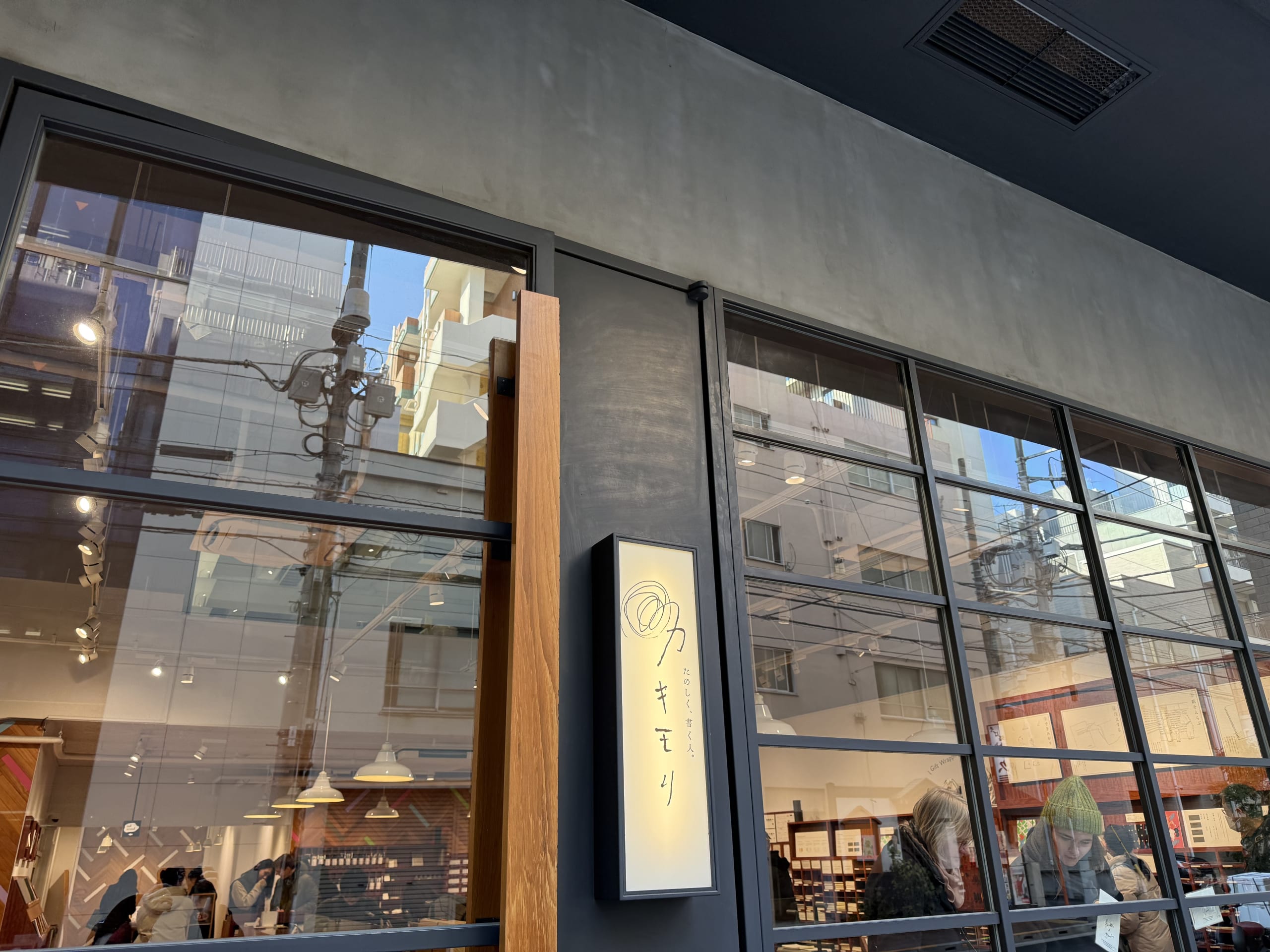 文具店カキモリの外観。大きなガラス窓に街の風景が反射している。
