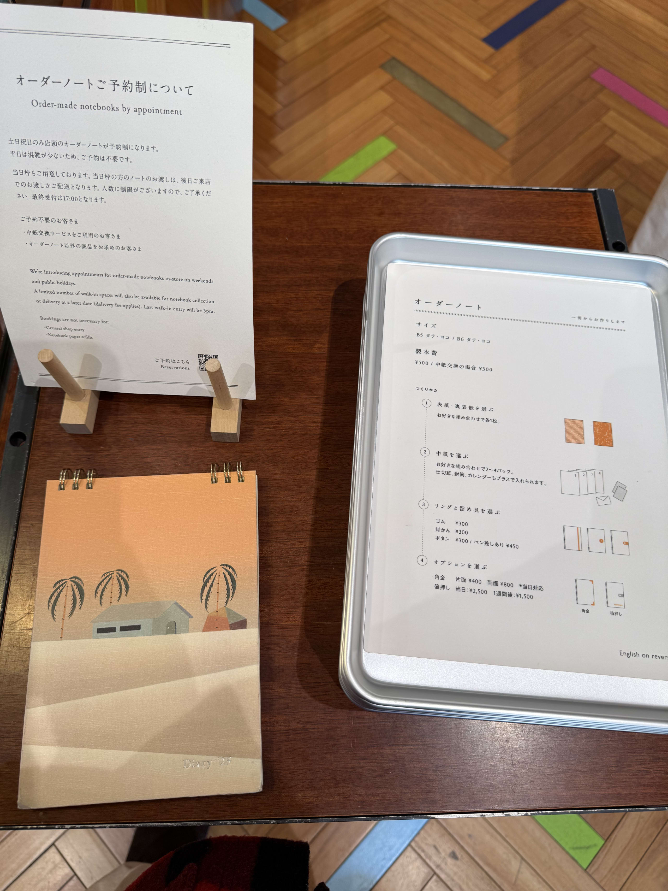 木製カウンター上のノート注文案内とサンプル。