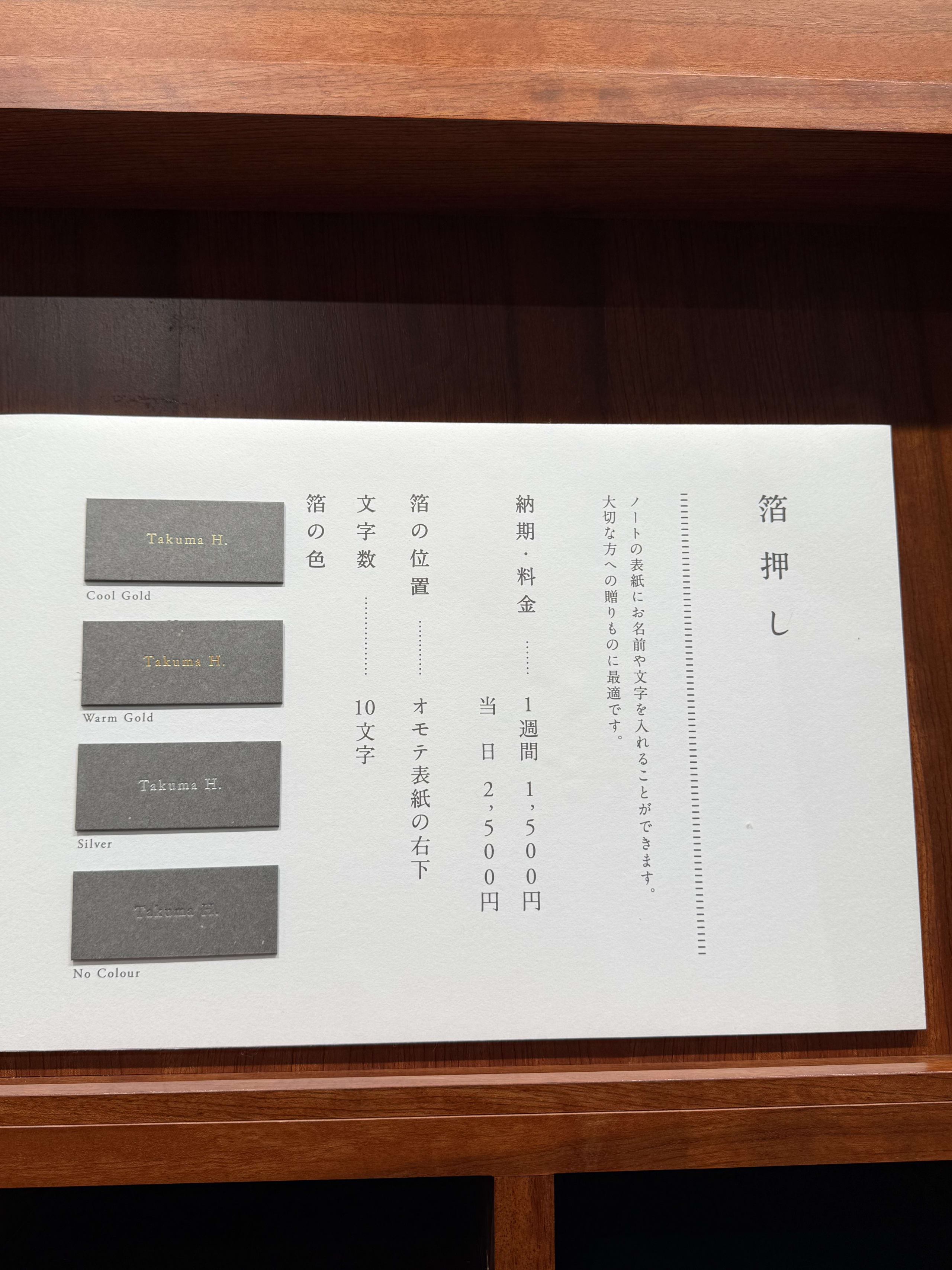 木製カウンターの箔押しサービス案内と4色のサンプル。