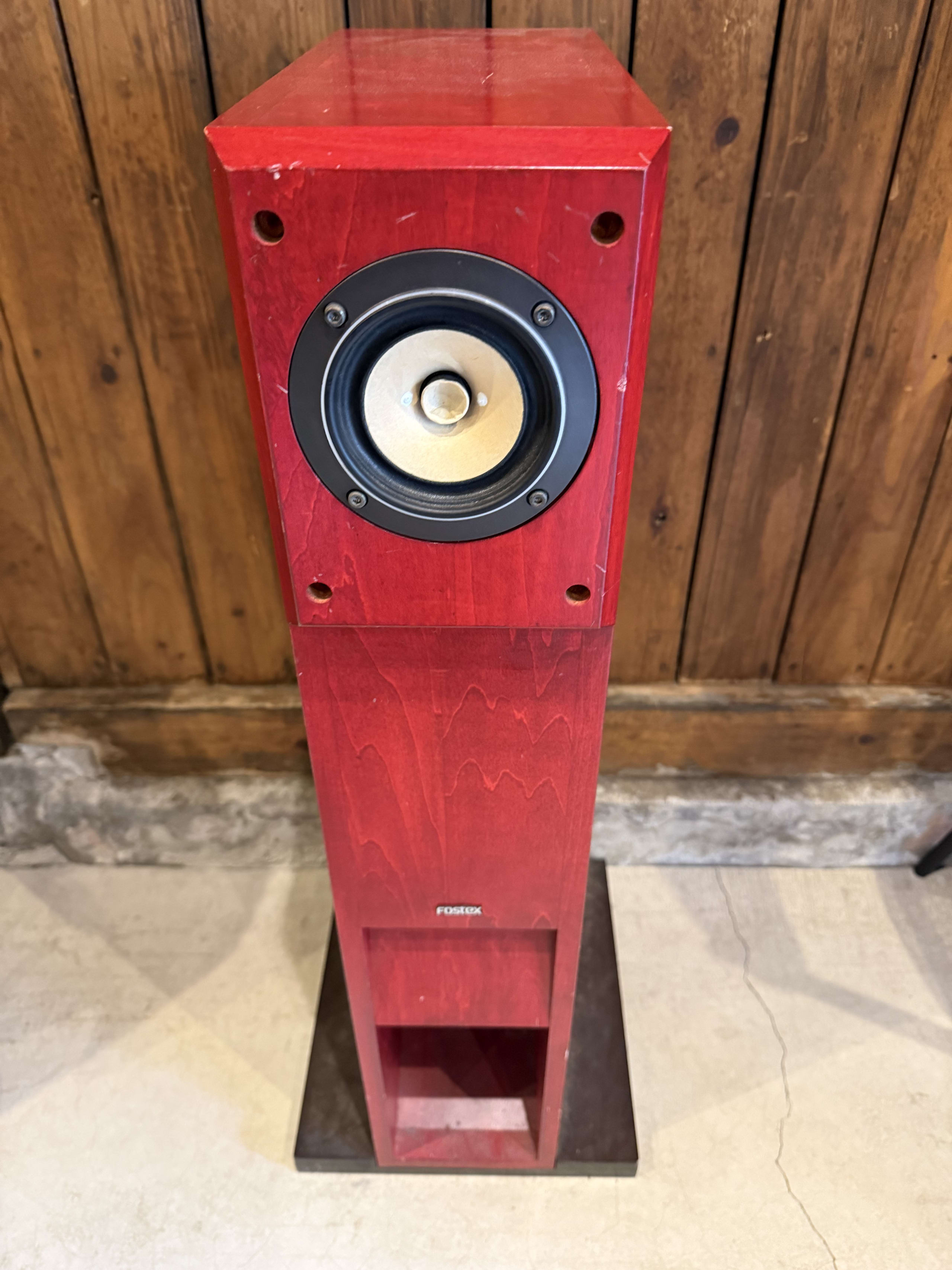 木壁とモルタル床を背景にしたFOSTEX製赤いスピーカー。