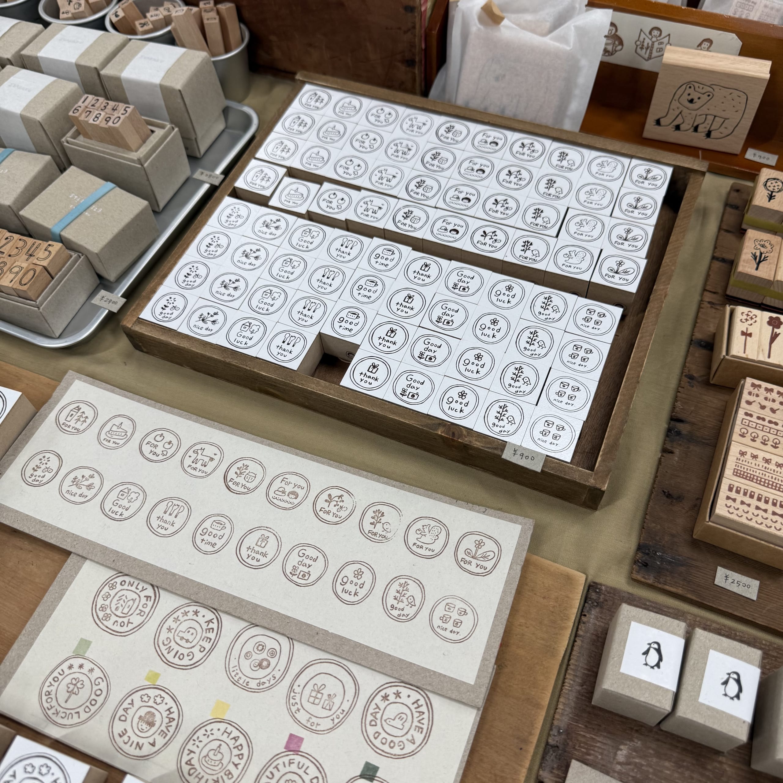 木箱に並ぶイラスト入りスタンプと試し押し見本。