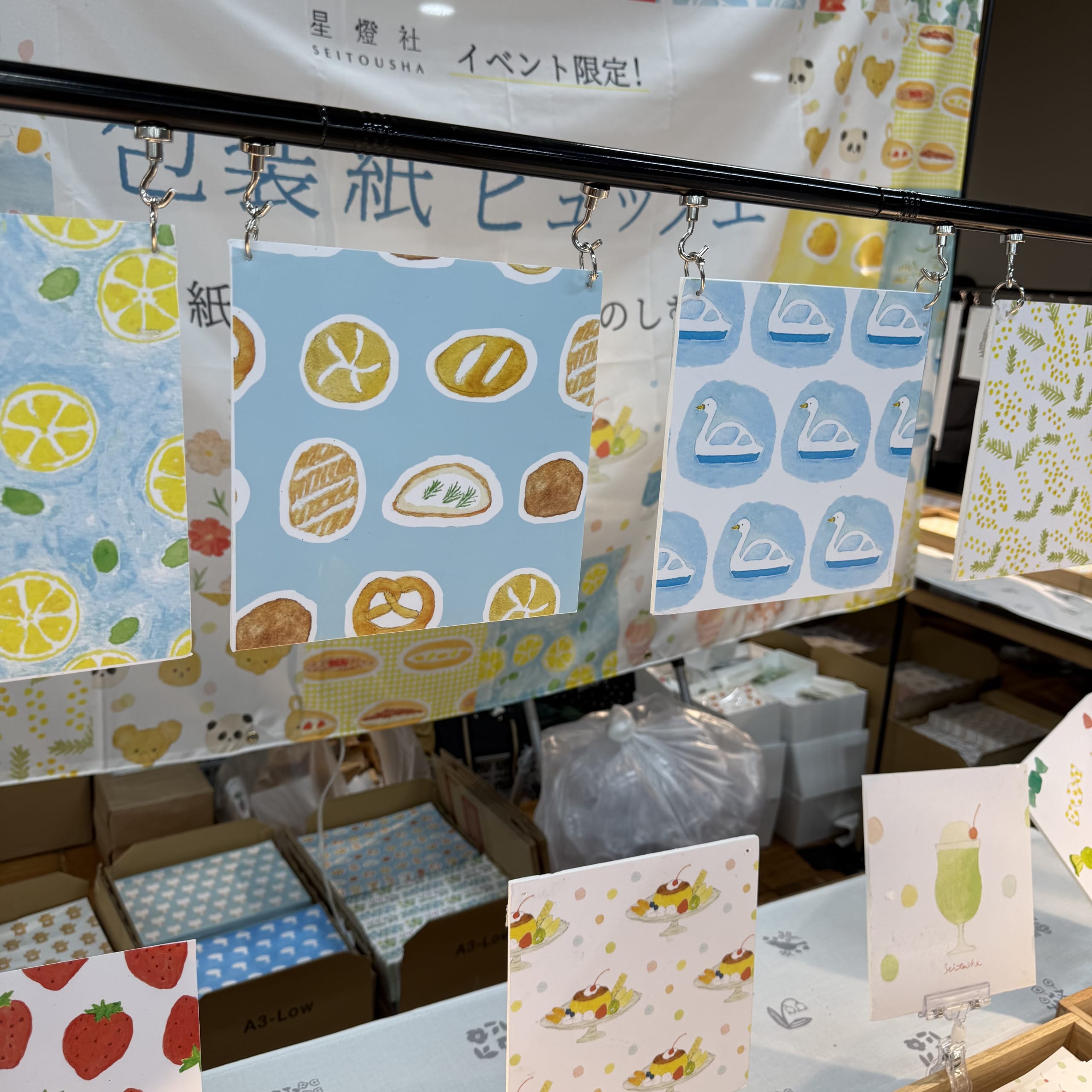 星燈社のブースに吊るされた水彩柄の包装紙見本。