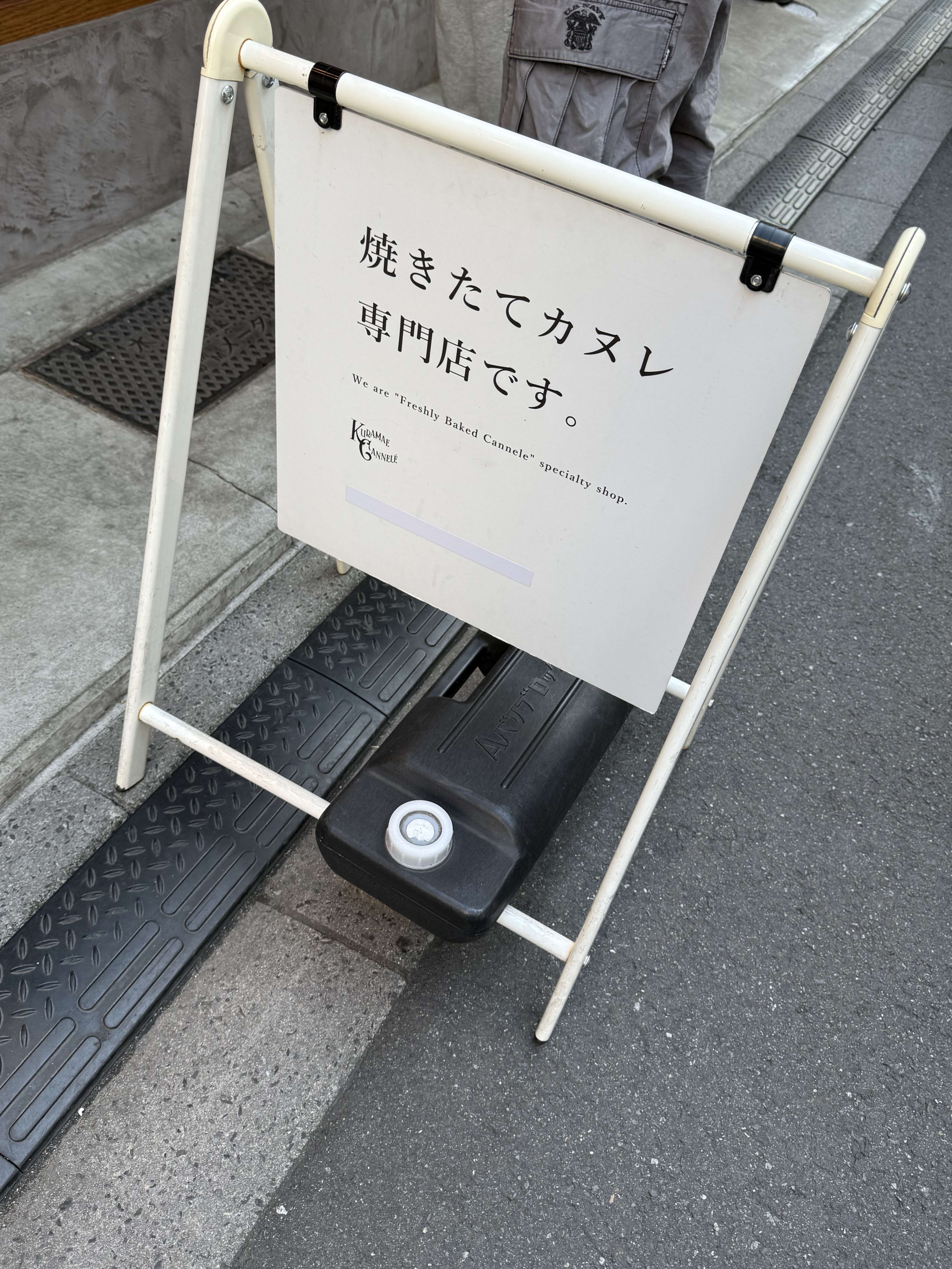 「焼きたてカヌレ専門店です。」と書かれた白い看板。