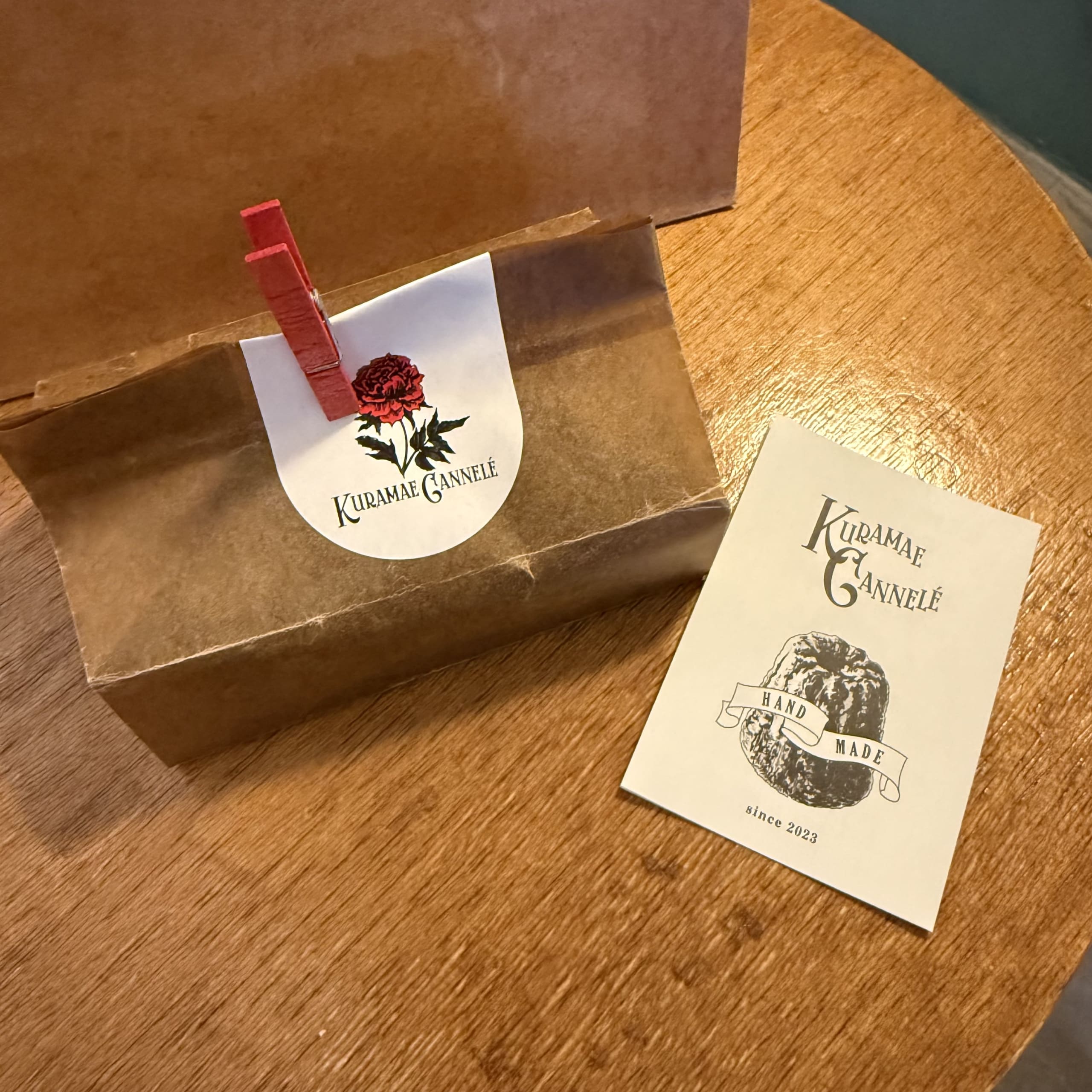 クラフト袋と赤いクリップが目を引くクラマエカヌレのパッケージとカード
