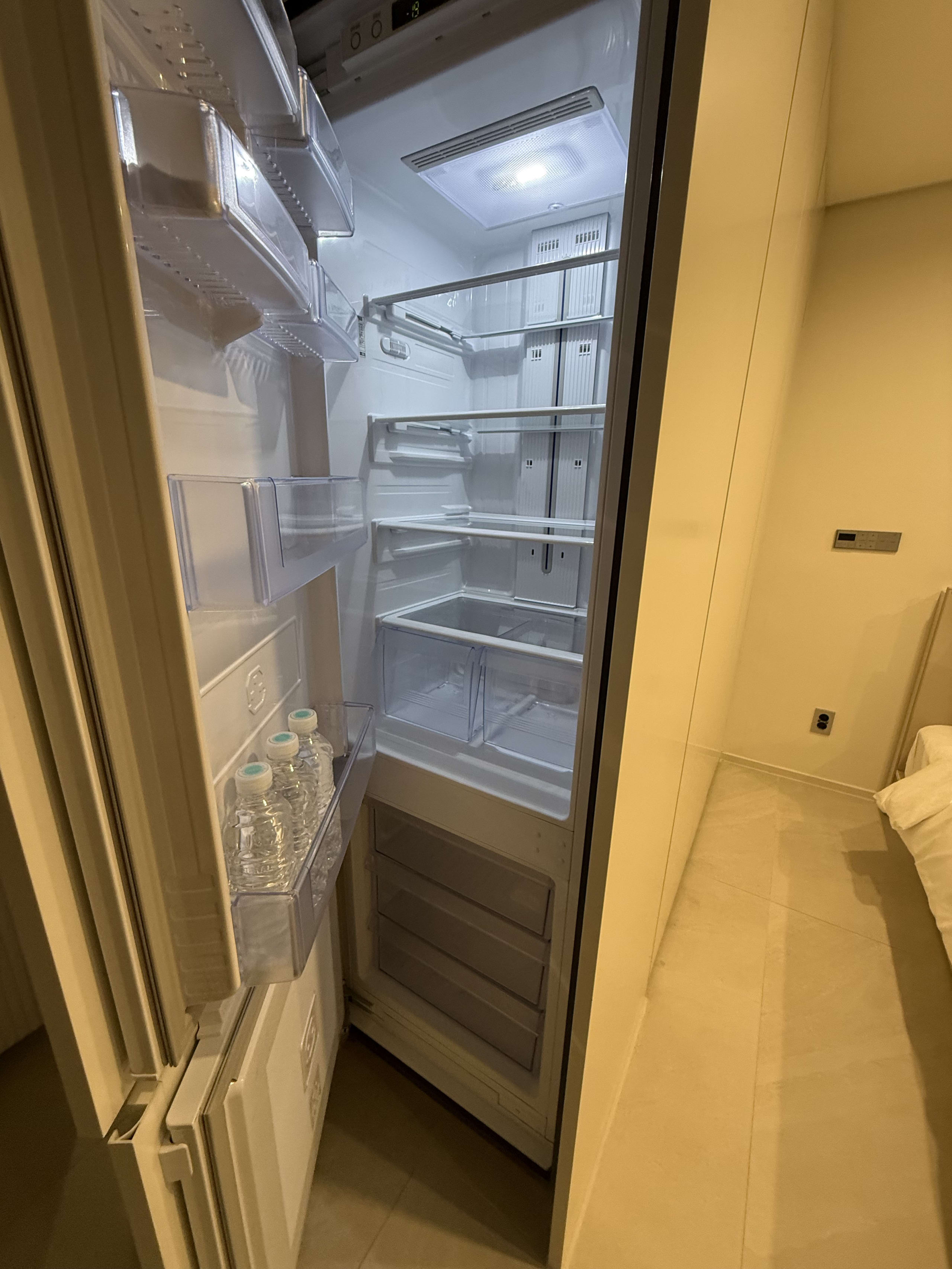 水が入ったホテルの開いた大型冷蔵庫。