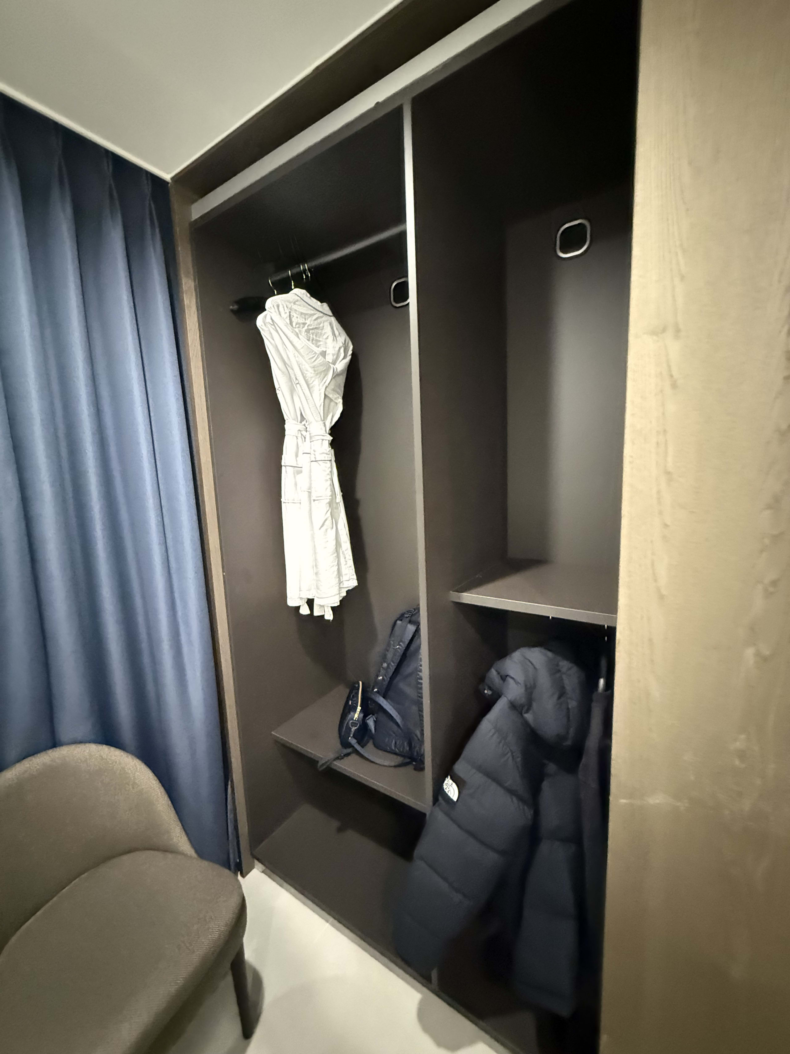 黒い衣類ケア家電の内部。バスローブやダウンが収納されている。