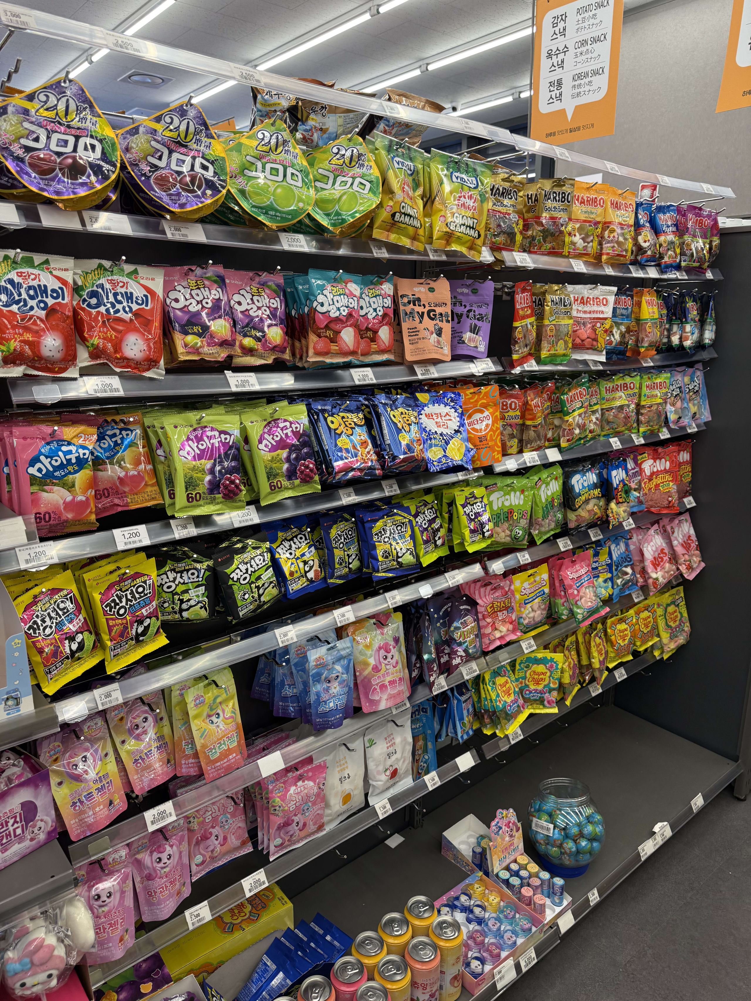 韓国のコンビニに並ぶ、色鮮やかなパッケージのお菓子の陳列棚。