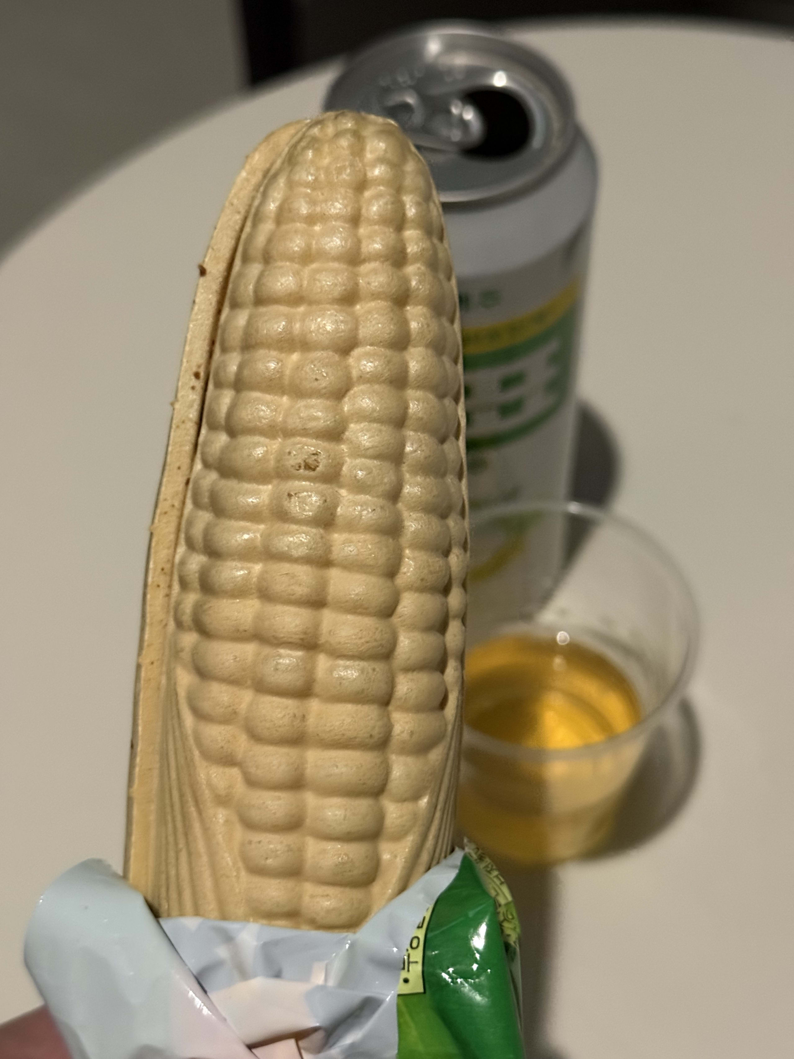 とうもろこし型アイスと缶ビールが置かれた白いテーブル。