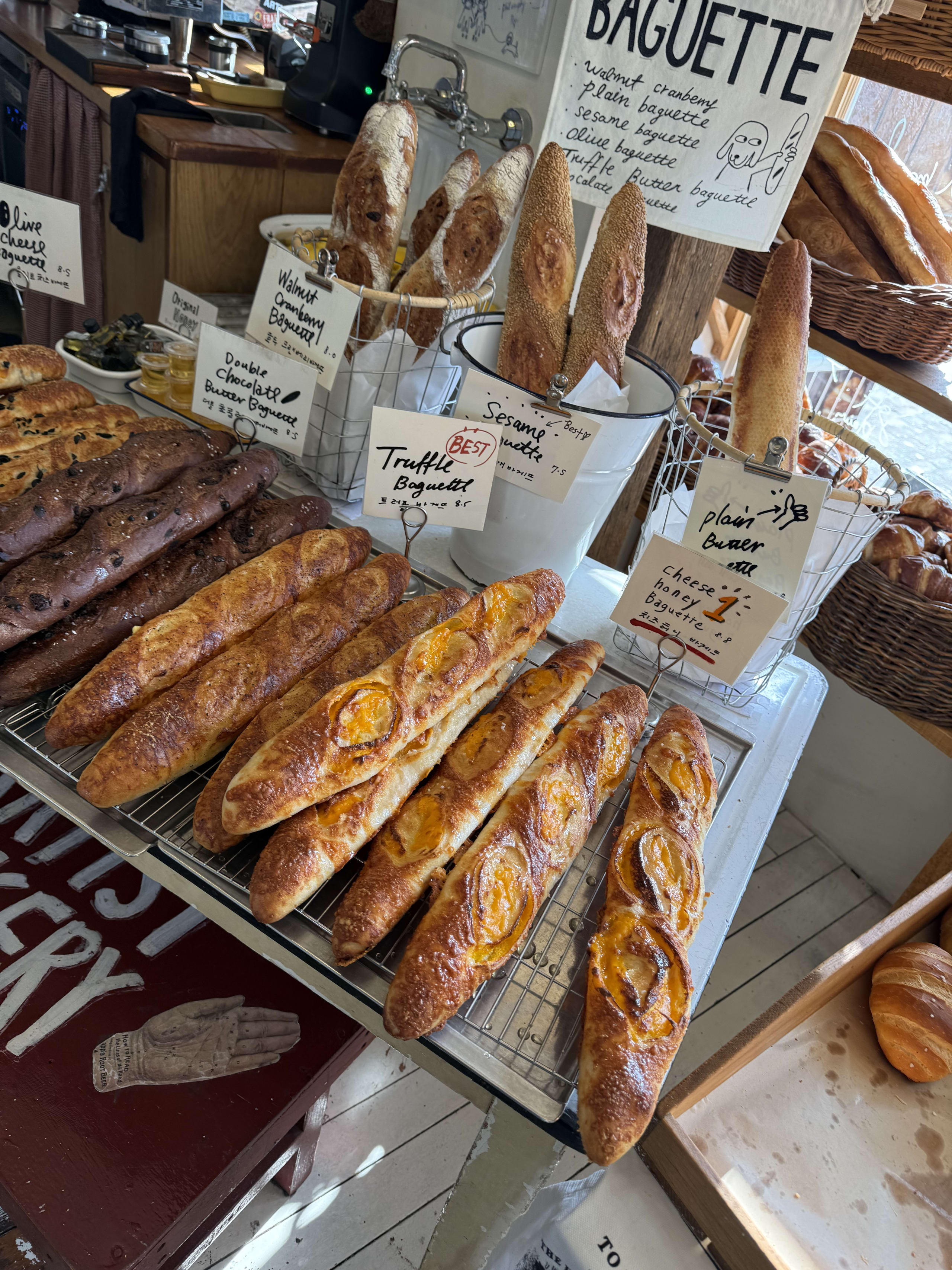店舗に並ぶ多様なバゲットと手書きポップ。