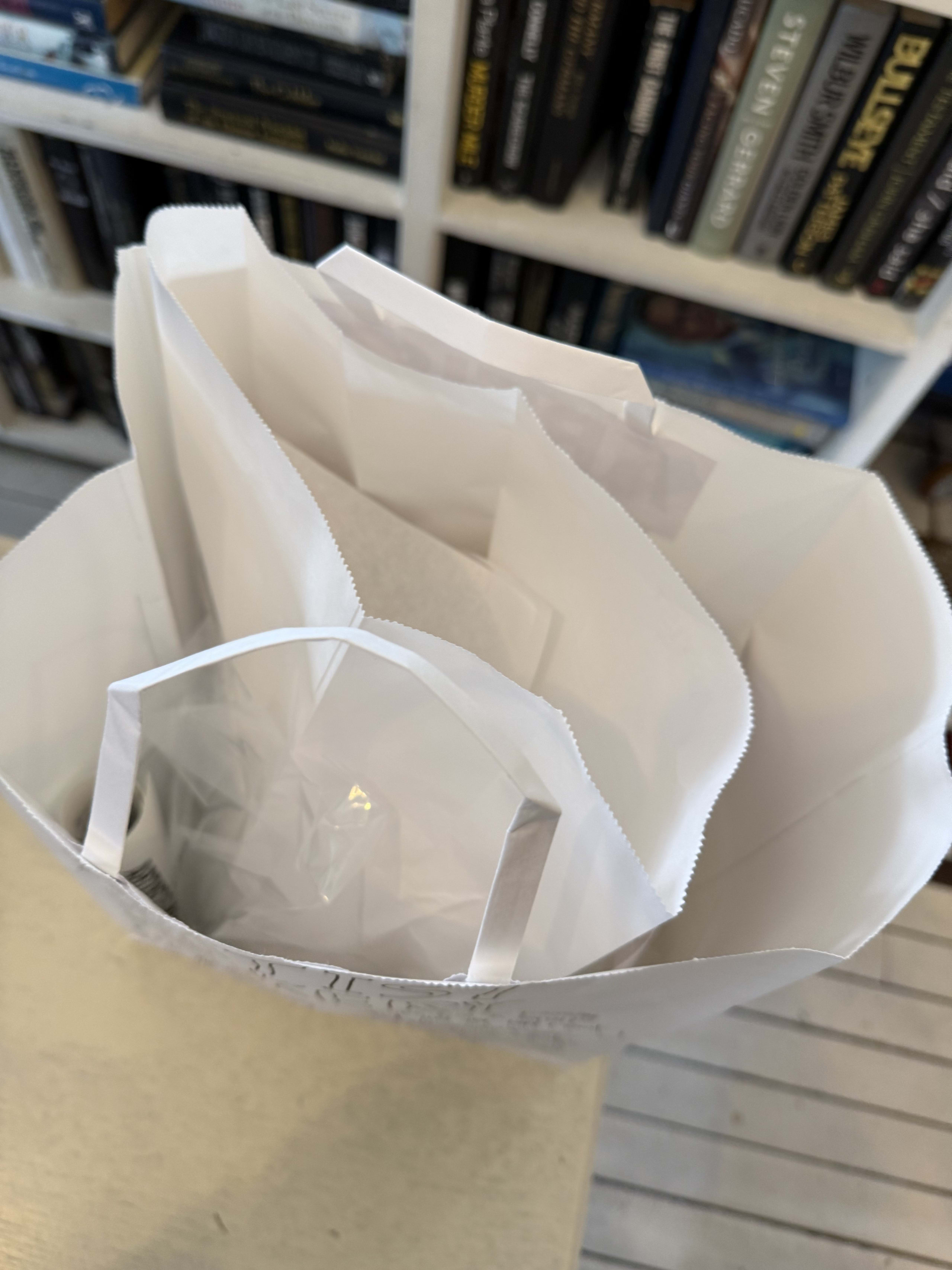 パンが入った白いテイクアウト用紙袋。