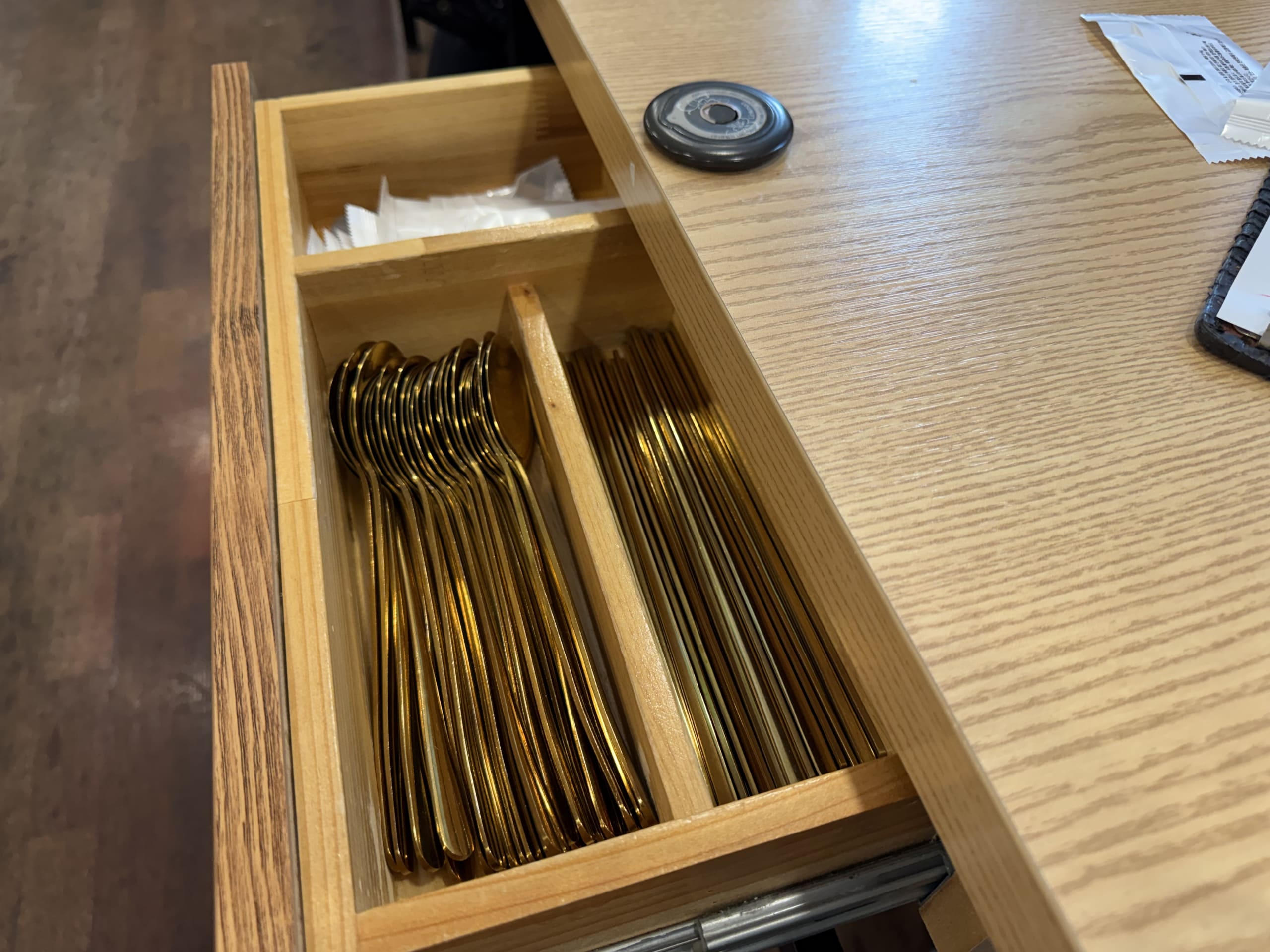引き出しに収納された真鍮色のスプーンと箸。