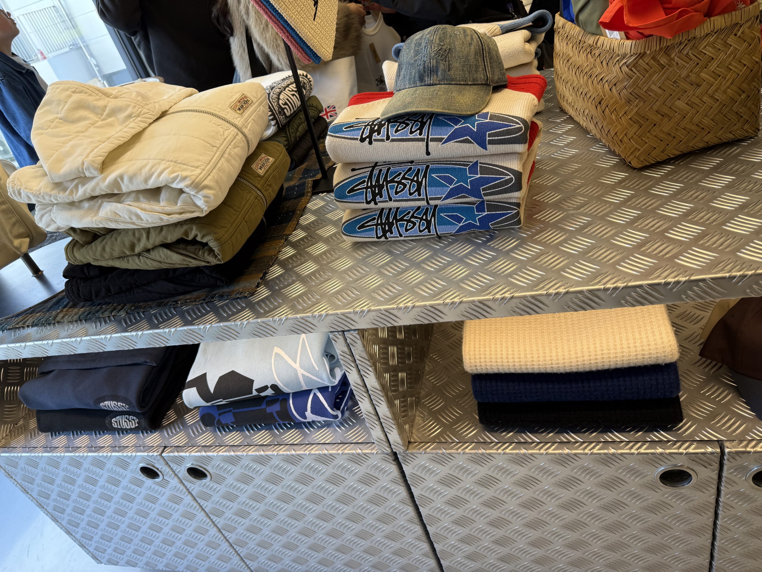 Stussy Seoulのアルミ什器に並ぶ新作アパレル。