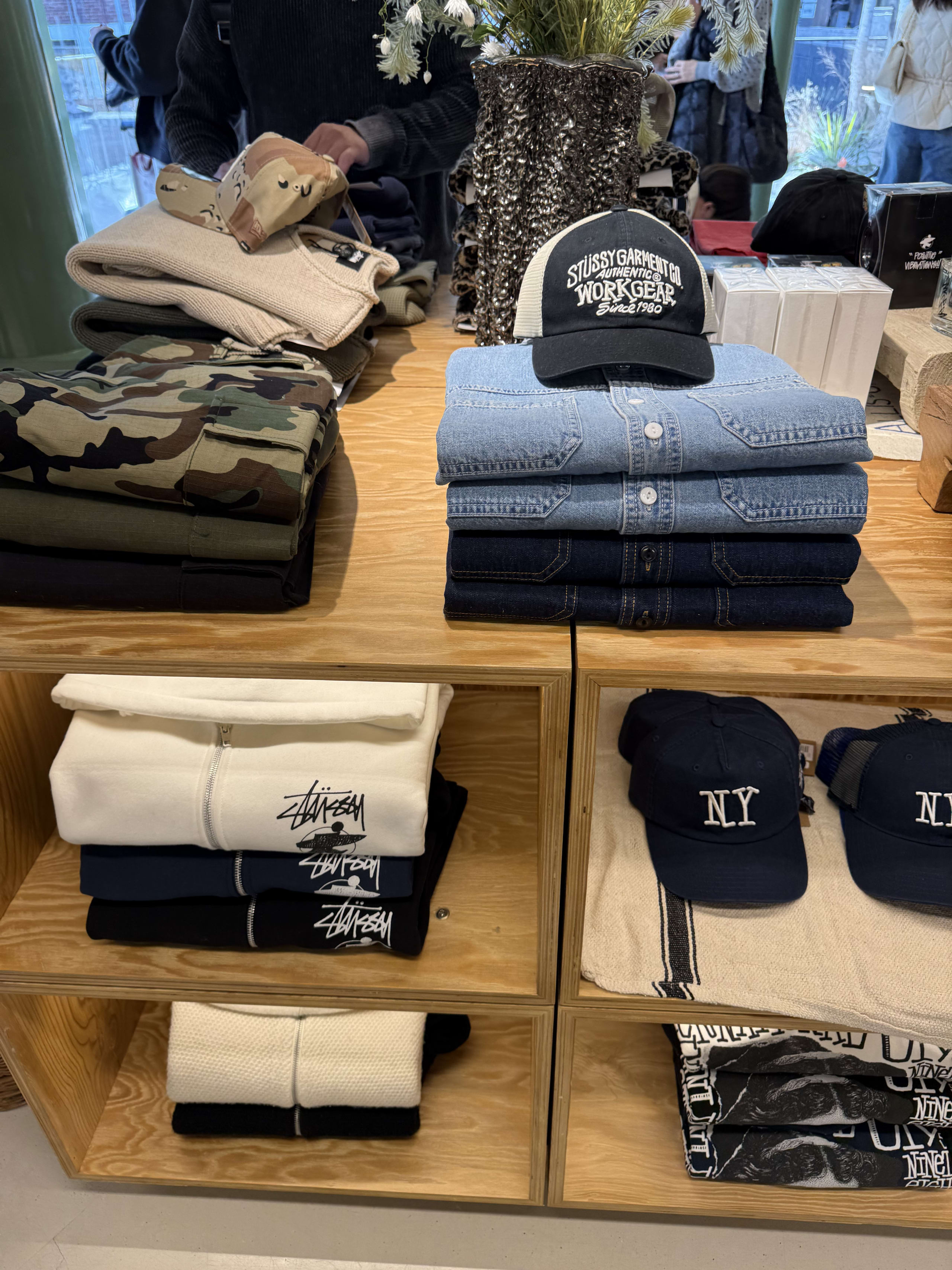 木製棚に並ぶStussyのシャツやパーカー。