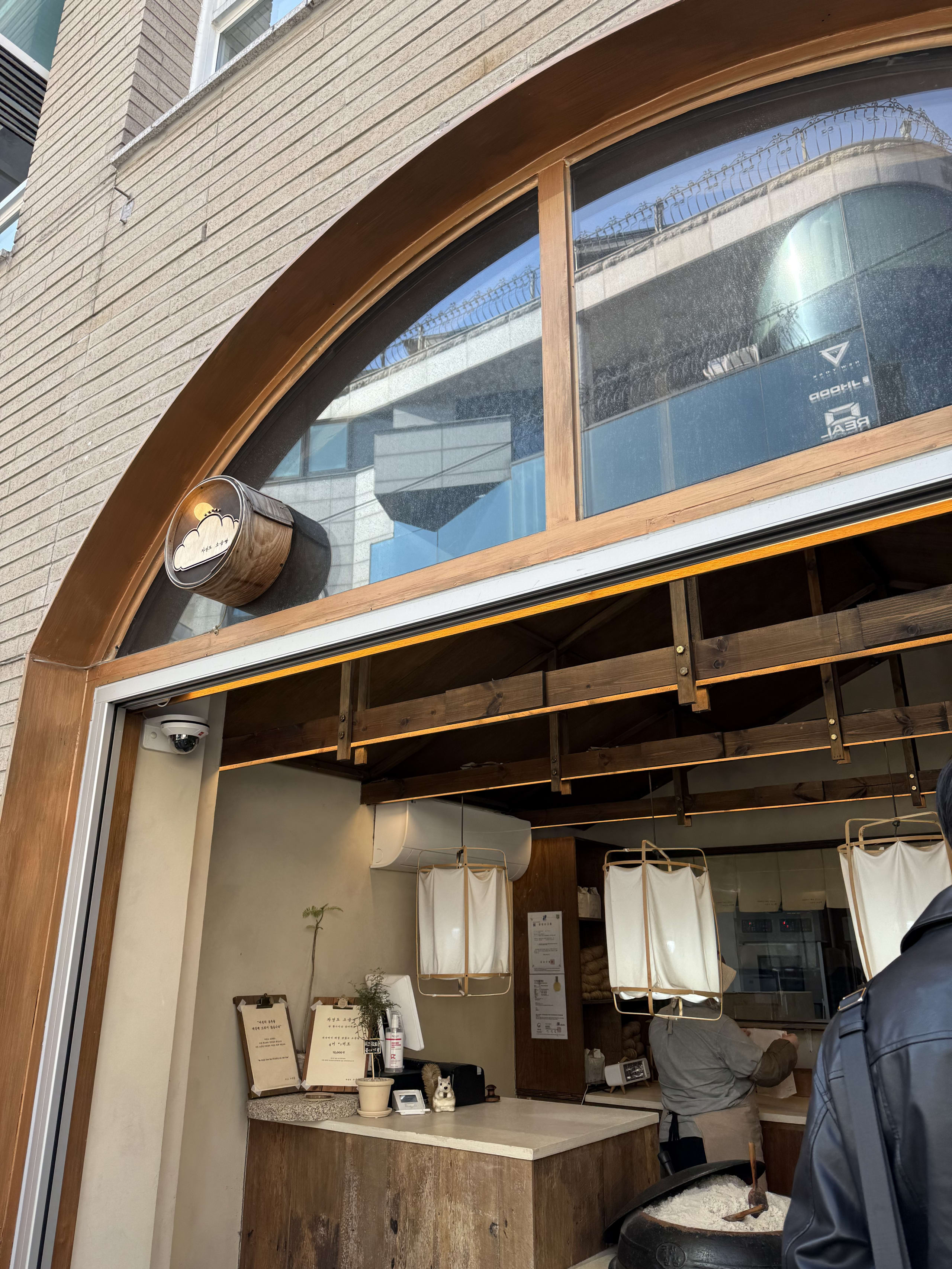 自然島塩パン狎鴎亭店の外観。木製アーチ窓、店先の塩釜、店内の様子が写る。