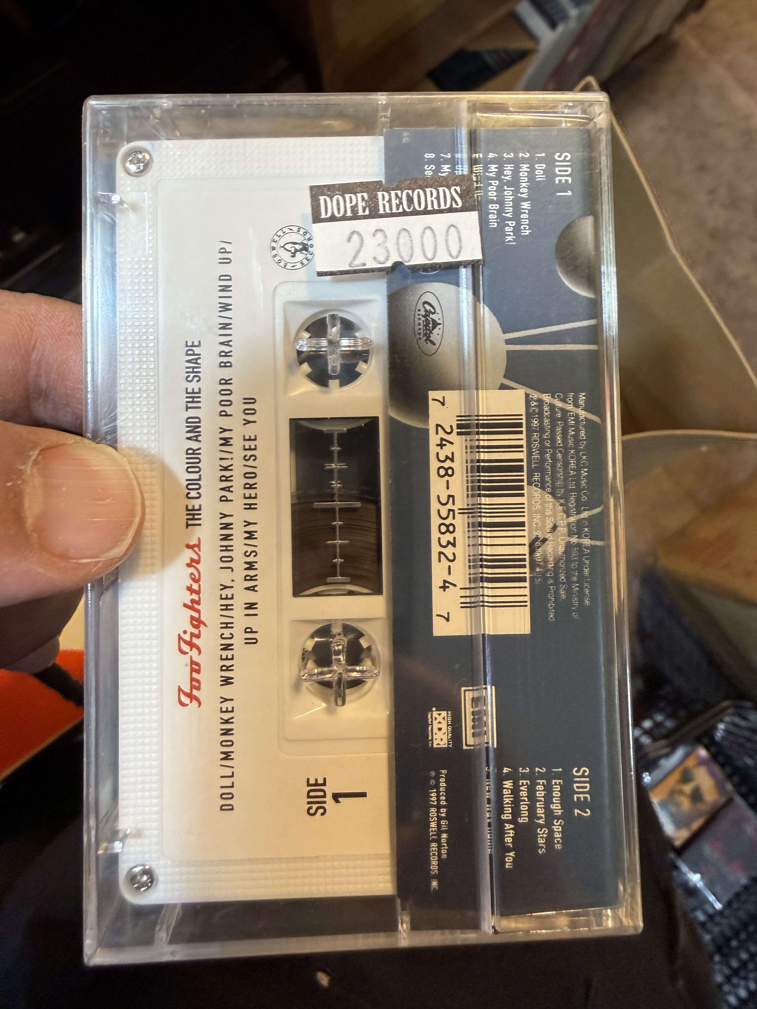 Foo Fightersのカセットテープを持つ手。DOPE RECORDSの値札付き。