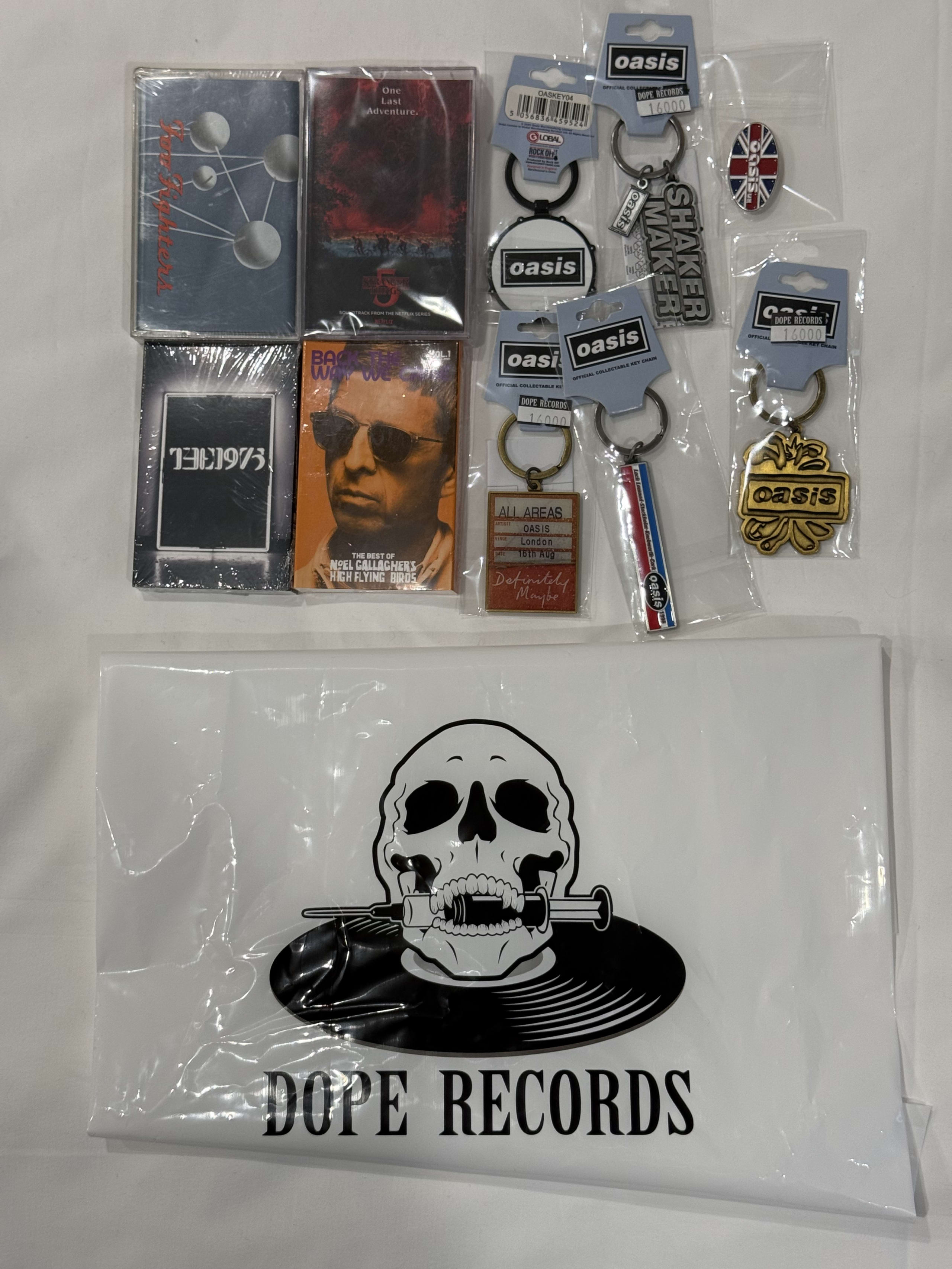 カセット4本、Oasisグッズ6点と店舗の袋。