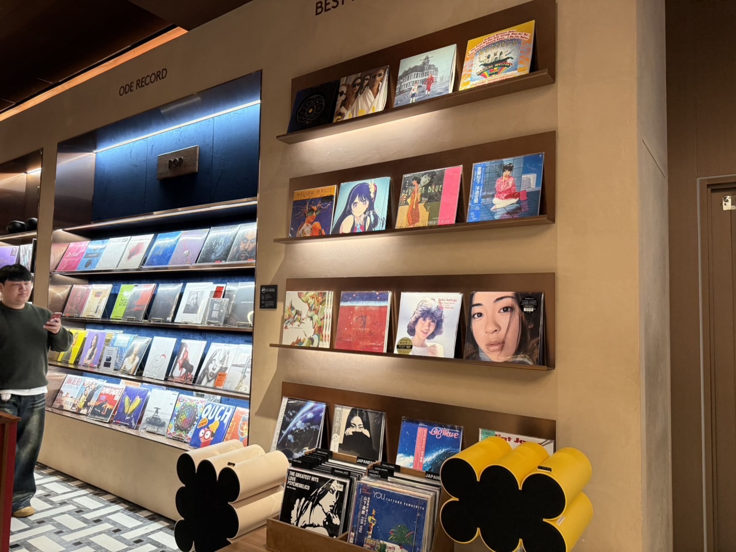 ヒュンダイソウルのレコード店で壁面の名盤を見る男性。