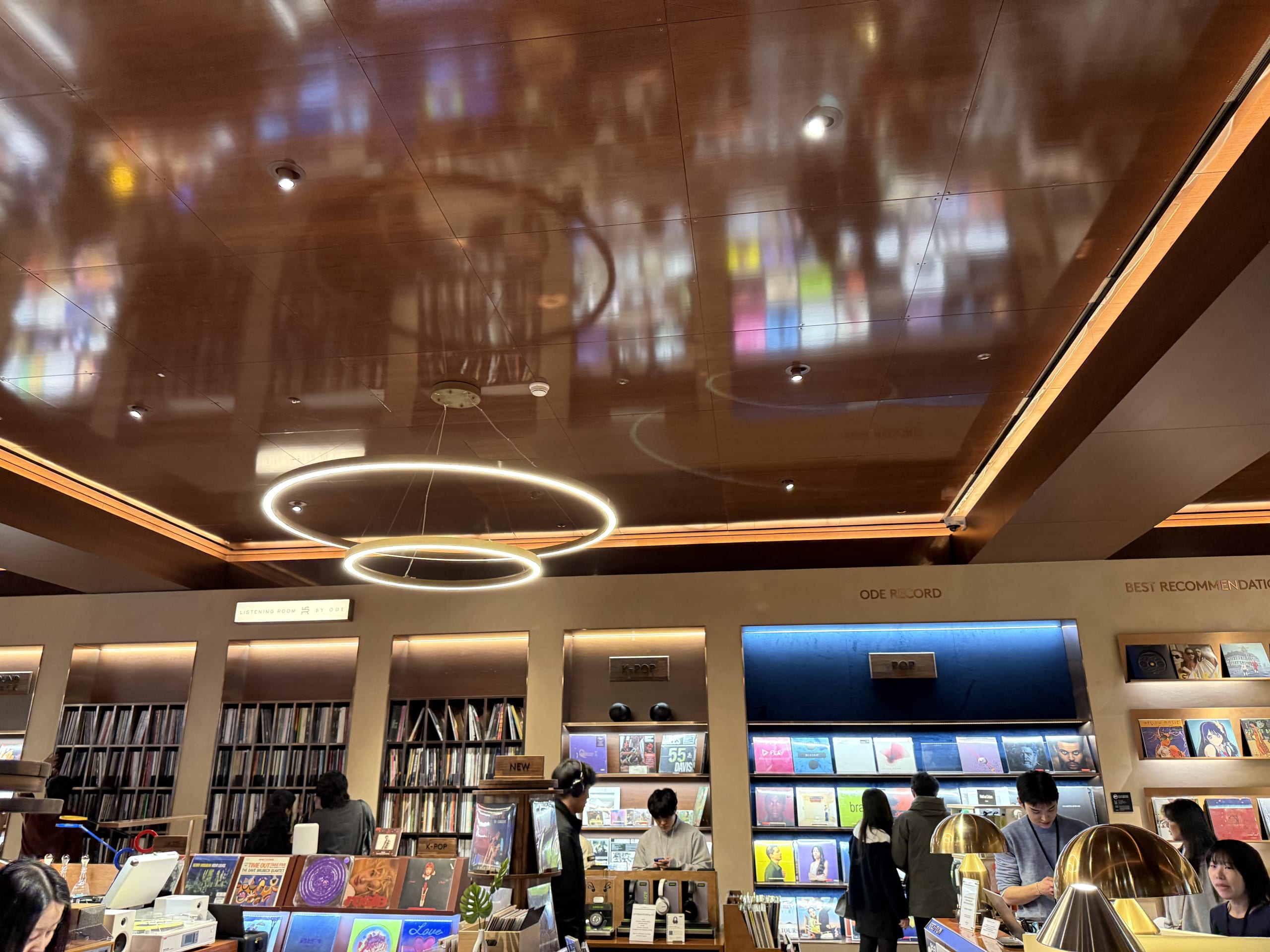 ヒュンダイソウル内のレコード店。艶やかな天井にジャケットが反射し、客が試聴している。