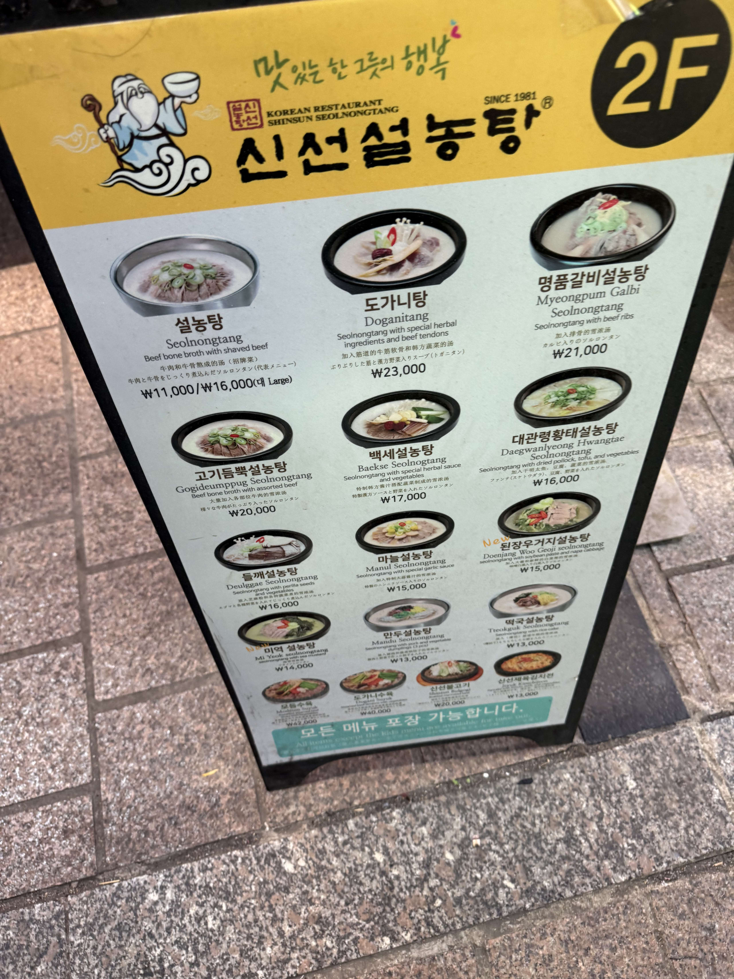 明洞の路上にある神仙ソルロンタンの黄色いメニュー看板。