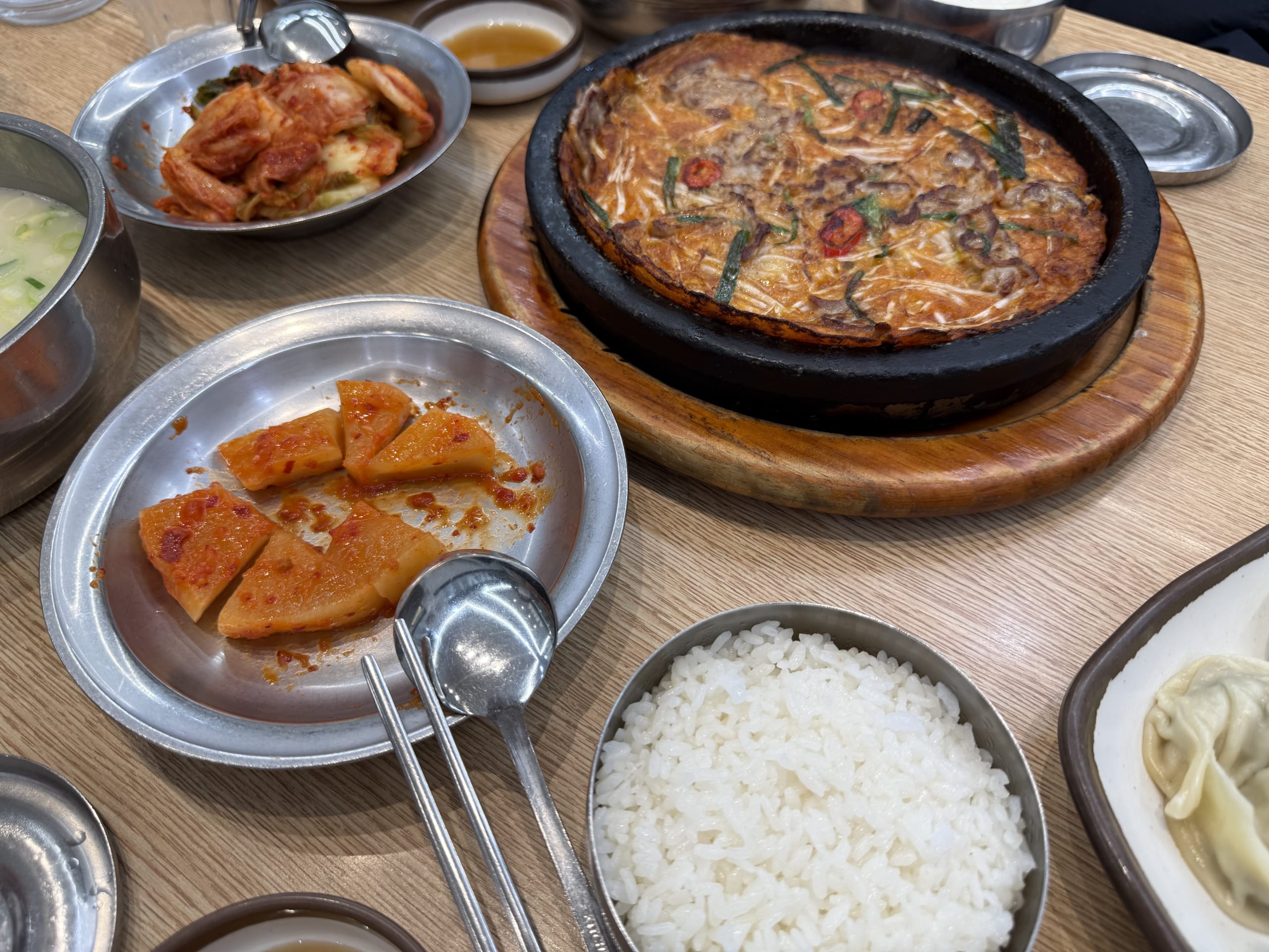 チヂミ、キムチ、ご飯が並ぶ神仙ソルロンタンの机。