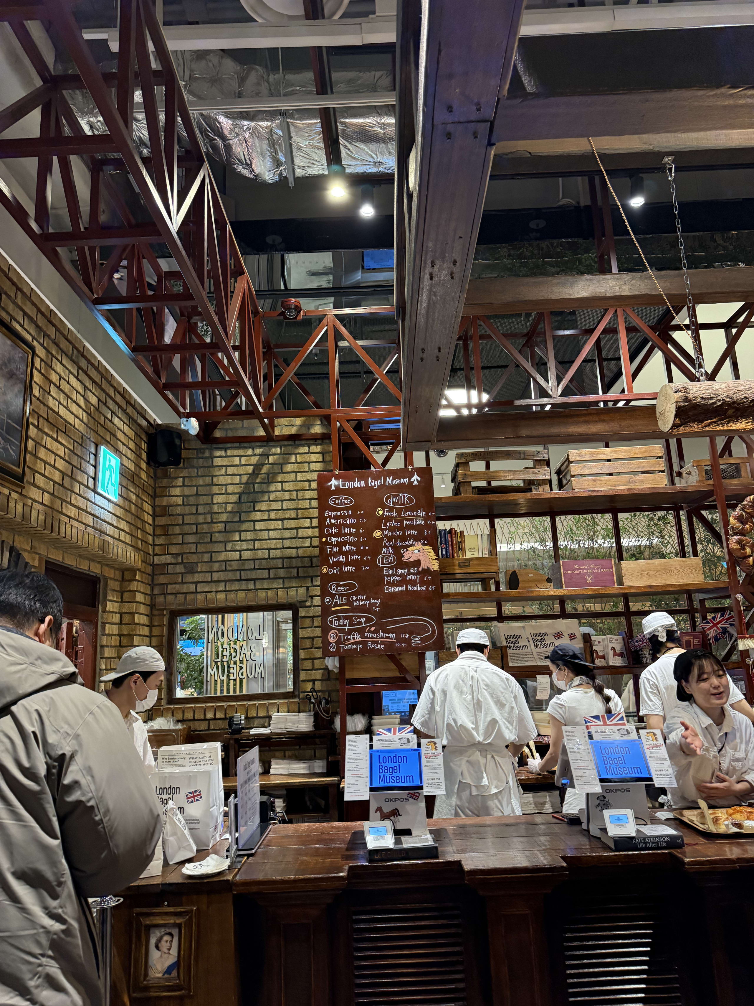 ロンドンベーグルミュージアムのレジ。レンガ壁とメニュー板がある。