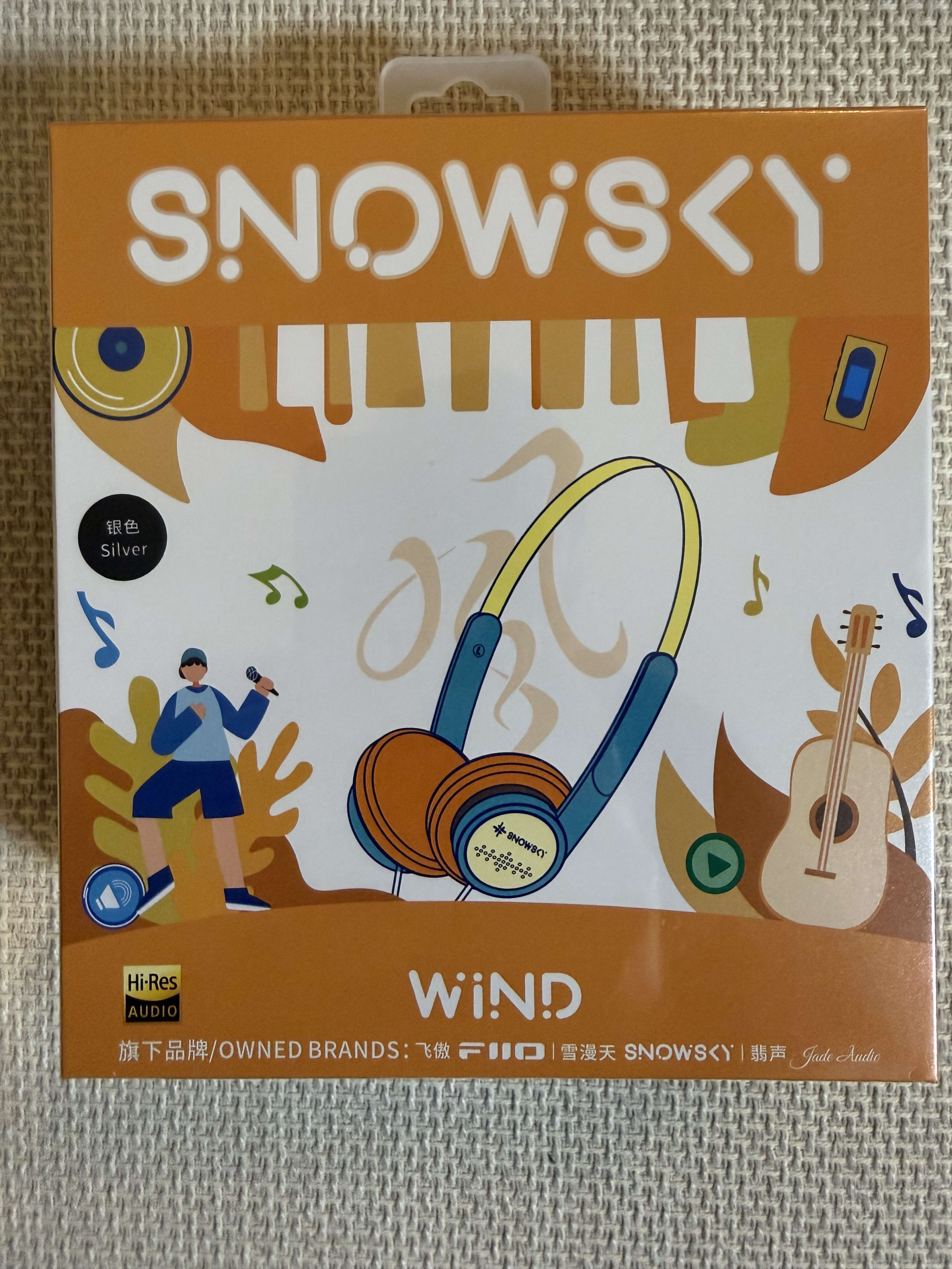 布の上に置かれたオレンジ色のSNOWSKY WINDヘッドフォンの箱。