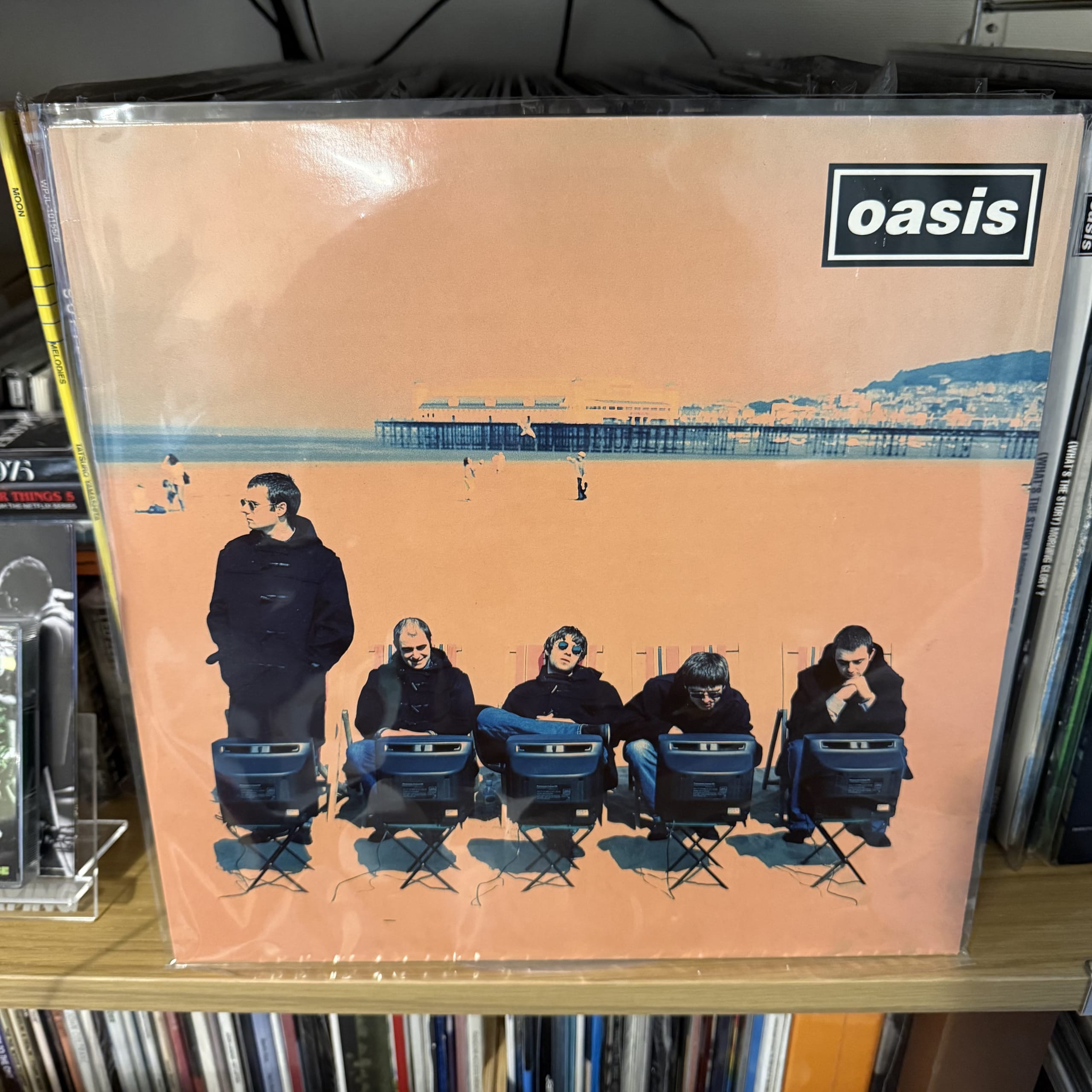 レコード棚に飾られたOasisのオレンジ色のレコードジャケット