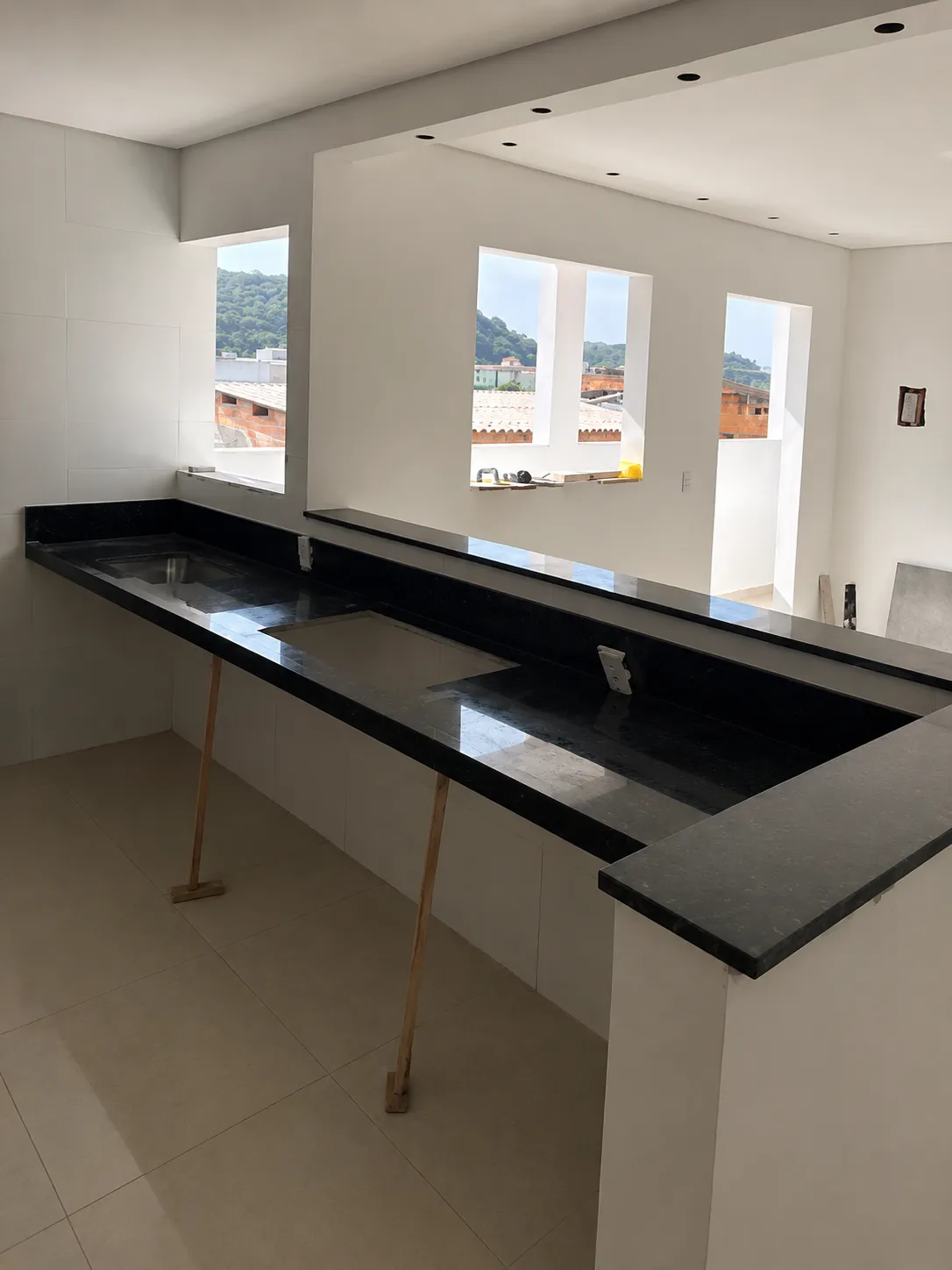 Bancada preta em cozinha ampla