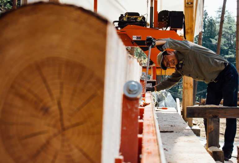 Woodworker Tak Yoshino turning a log on LT15 sawmill