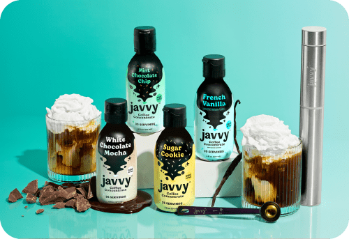 A glass full of Iced Coffee and some Javvy Coffee Concentrate on the side.