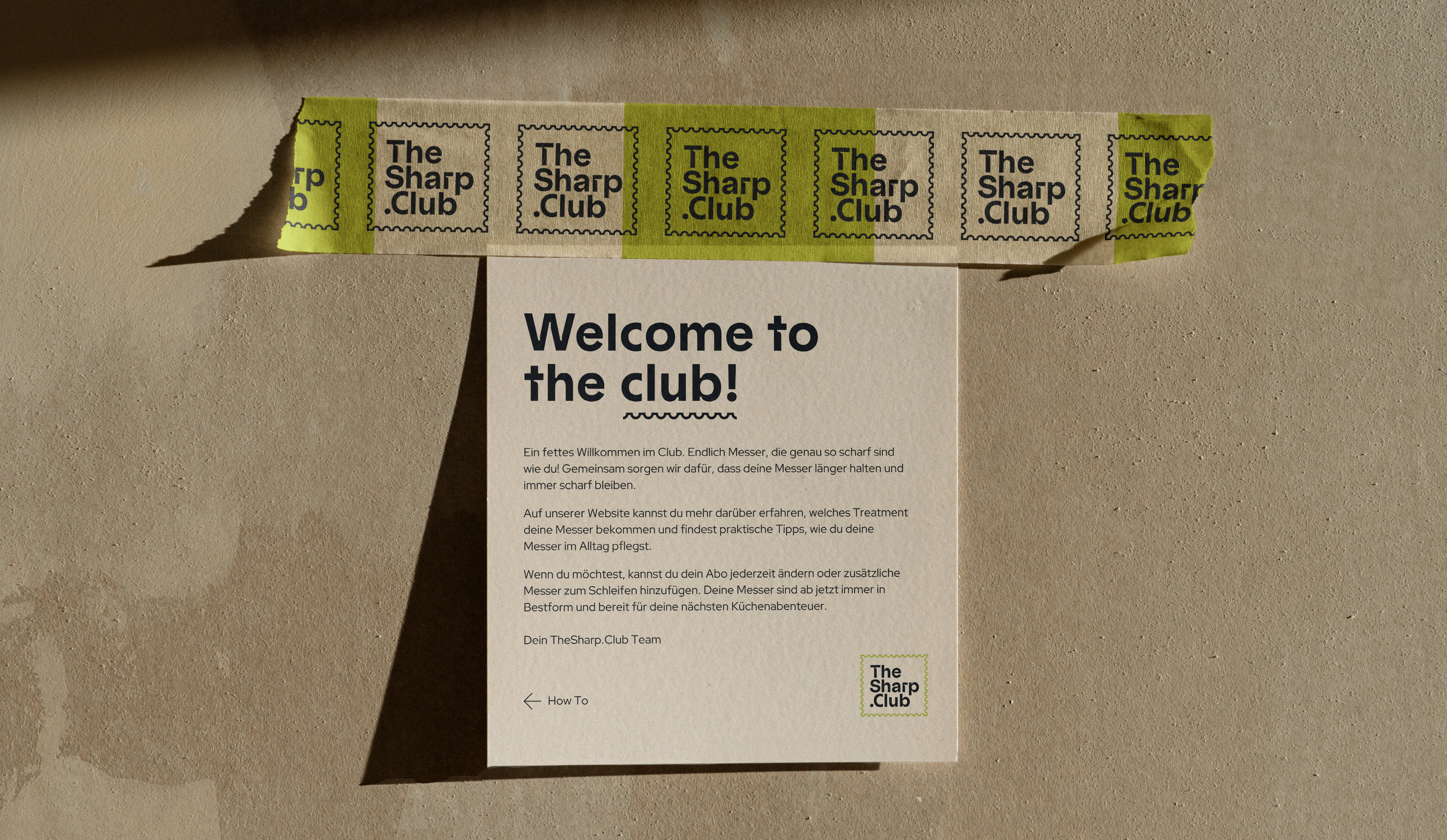 A minimalist flyer is attached to a beige wall with packing tape. The TheSharp.Club brand name can be seen on the green and white packing tape and on the flyer. The flyer says welcome to the club!