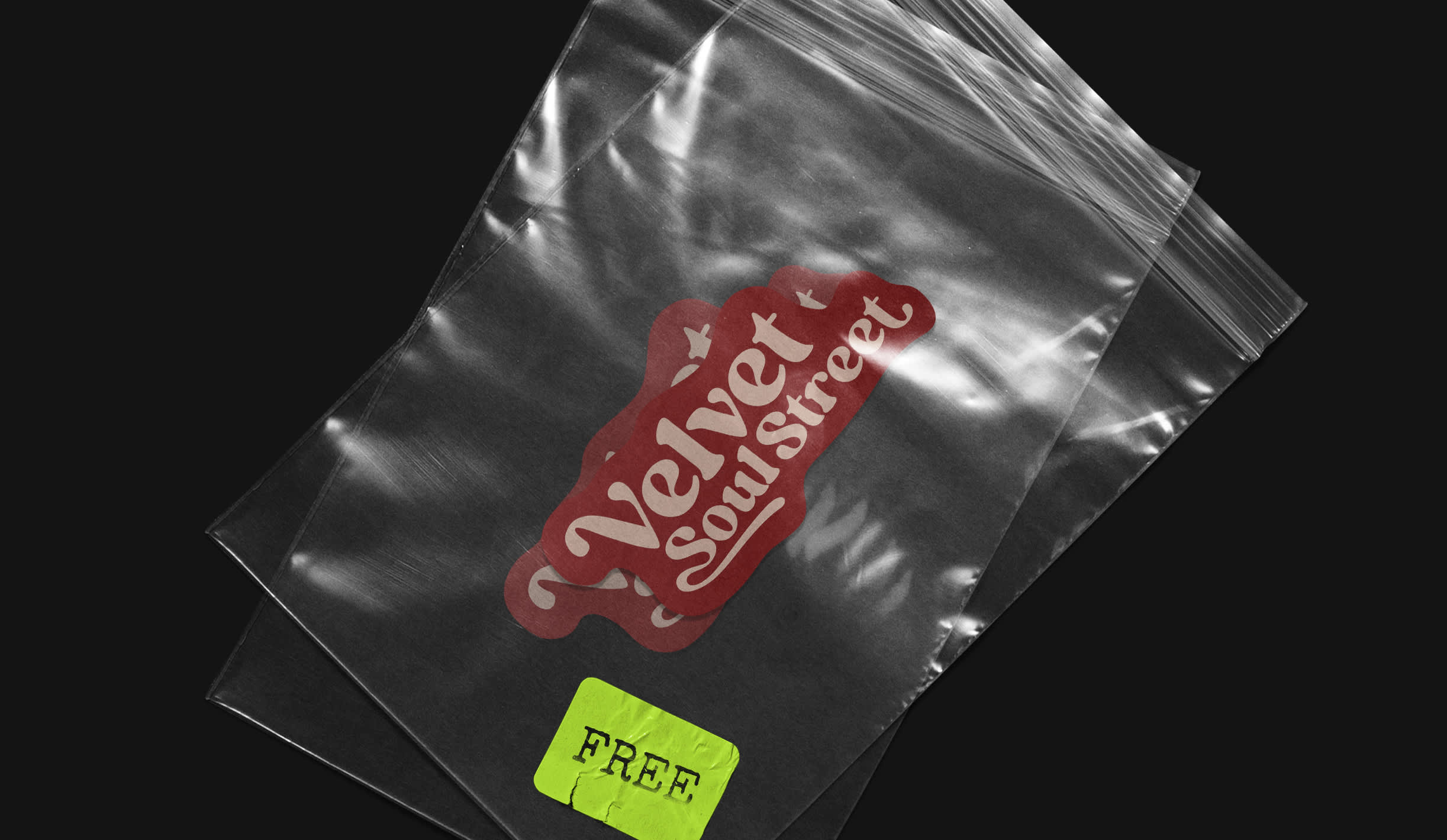 Two small transparent plastic bags are lying on concrete. The bags contain stickers of the band Velvet Soul Street.
