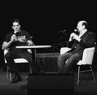 Black and white interview — two men on stage