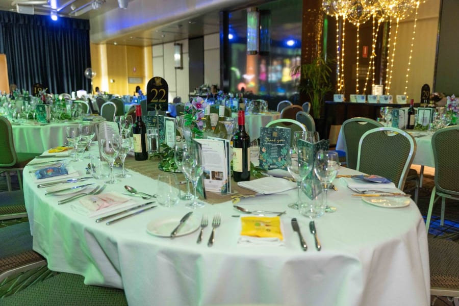 Gala dinner table styling with glassware, menus and floral centrepieces in a Sydney ballroom