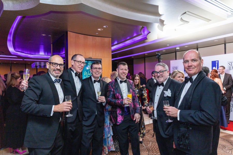 Guests in black tie raising champagne during pre-dinner networking at the Sydney Star Ball
