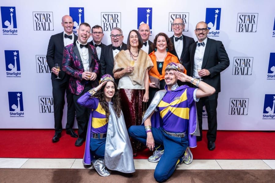 Gala guests on the red carpet with two Captain Starlight characters saluting in front