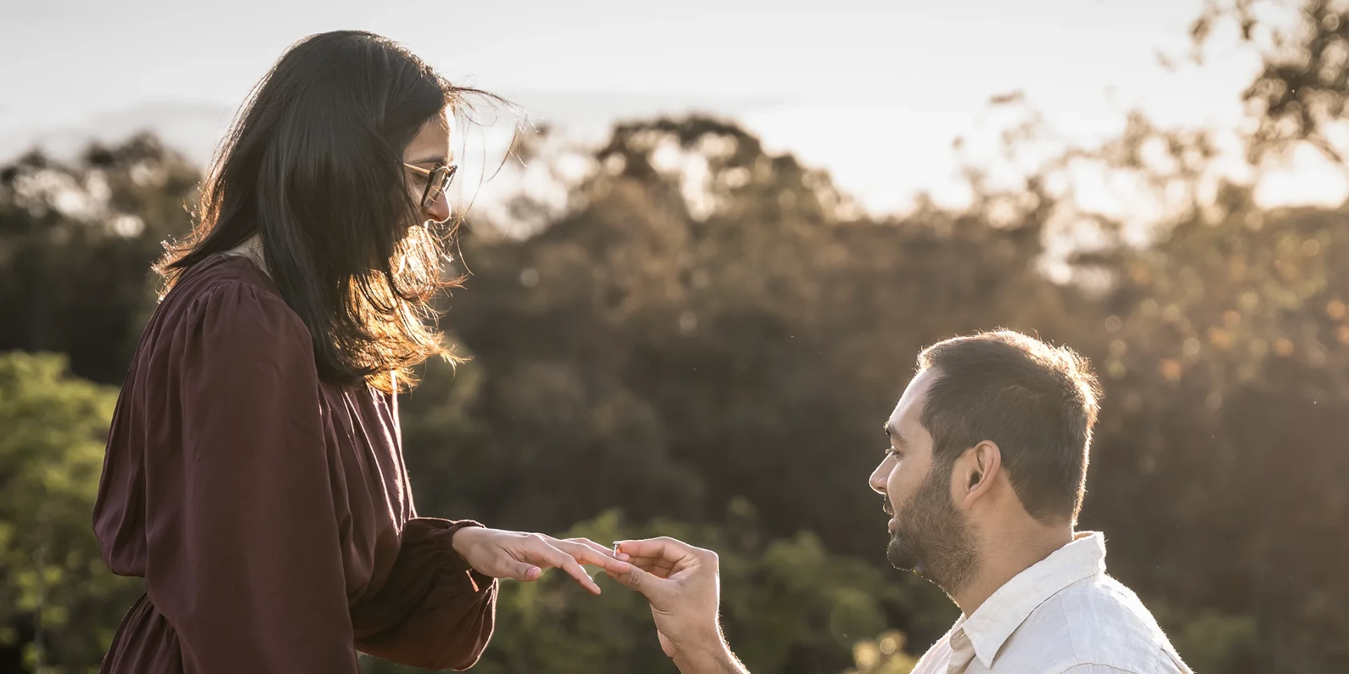 Man proposing to his partner in a golden grass field at Rouse Hill Regional Park