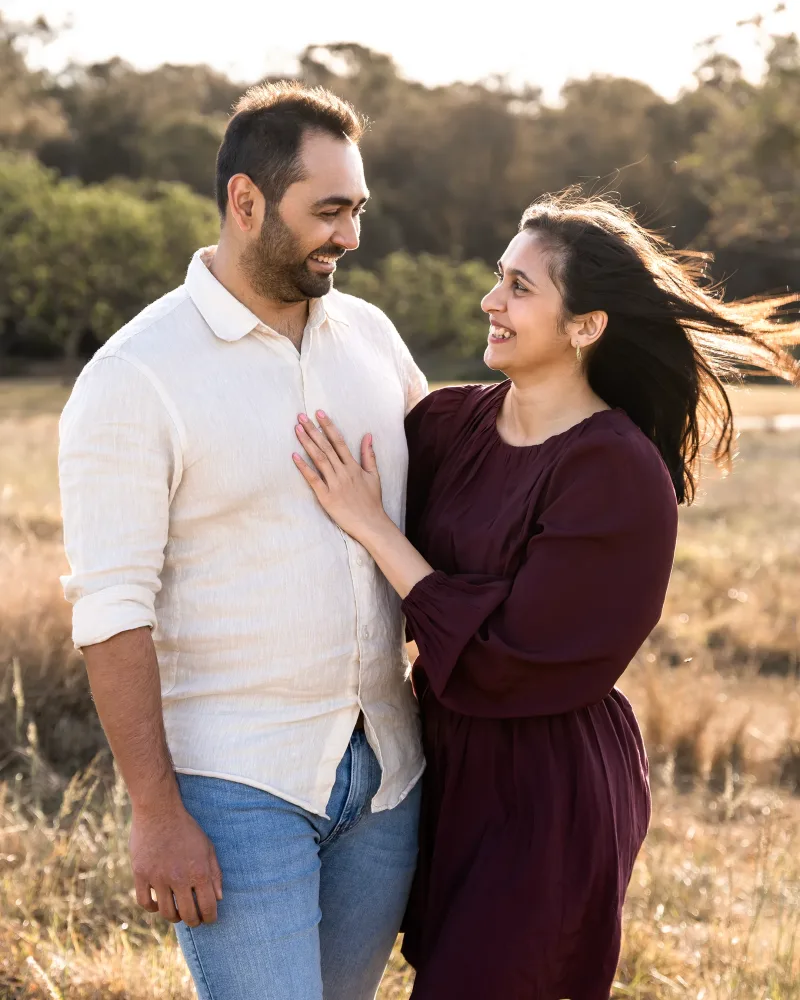 Close up romantic portrait of engaged couple with wind in her hair at Rouse Hill Regional Park