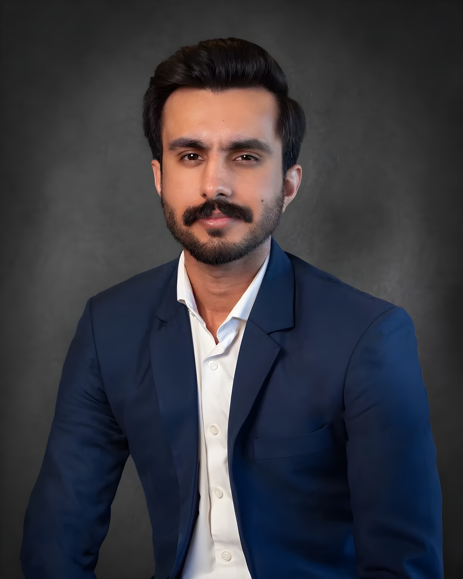 Professional corporate headshot of a man in a navy blazer and white shirt