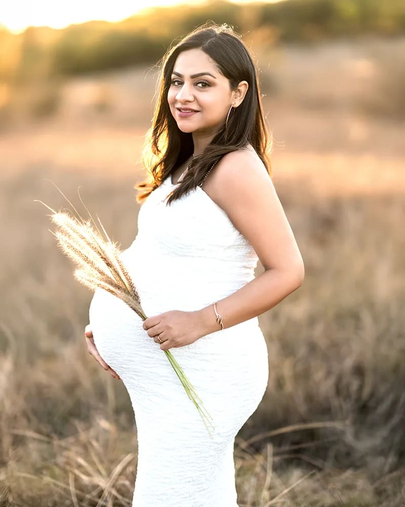 Maternity solo portrait white dress roses bouquet sunset field Hills District — Shekhar Jay Photography