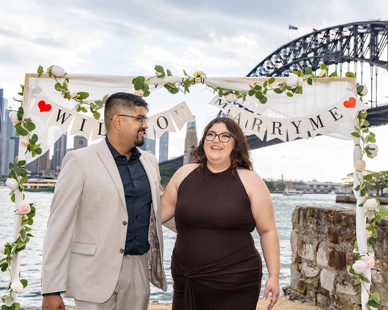 Sydney proposal photographer — Harbour Bridge arch couple laughing