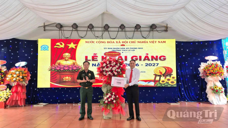 Đồng chí đại tá Đinh Xuân Hùng, Chính ủy Bộ đội Biên phòng tỉnh trao tặng máy in cho Trường THCS Lê Lợi, xã Phong Nha - Ảnh: H.N