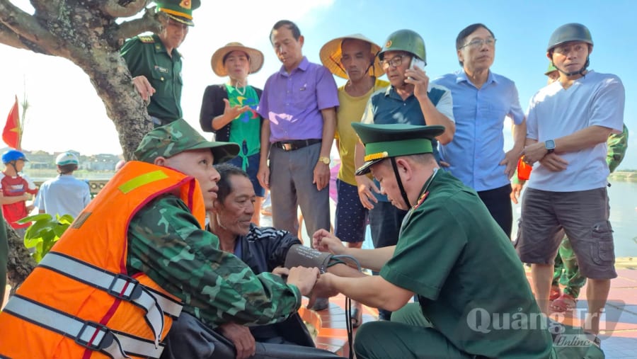 Cán bộ quân y Đồn Biên phòng Lý Hòa thực hiện thăm khám sức khỏe ban đầu cho ngư dân Nguyễn Tiến Châu ngay sau khi tàu cứu nạn cập bến. Ảnh: N.H