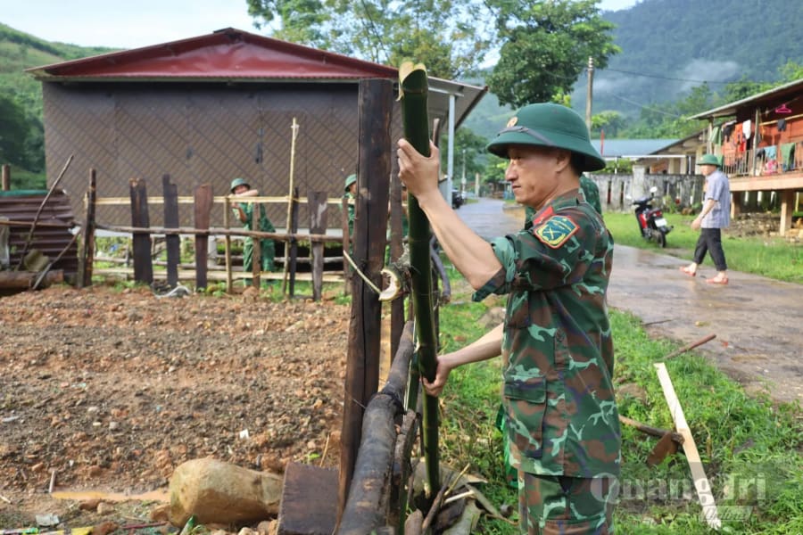 Cán bộ, chiến sĩ Bộ đội Biên phòng cùng người dân bản Lòm - K. Chăm, xã Dân Hóa xây dựng hàng rào, chỉnh trang khuôn viên, từng bước hình thành vườn nhà gọn gàng, sạch đẹp - Ảnh: Q.N.