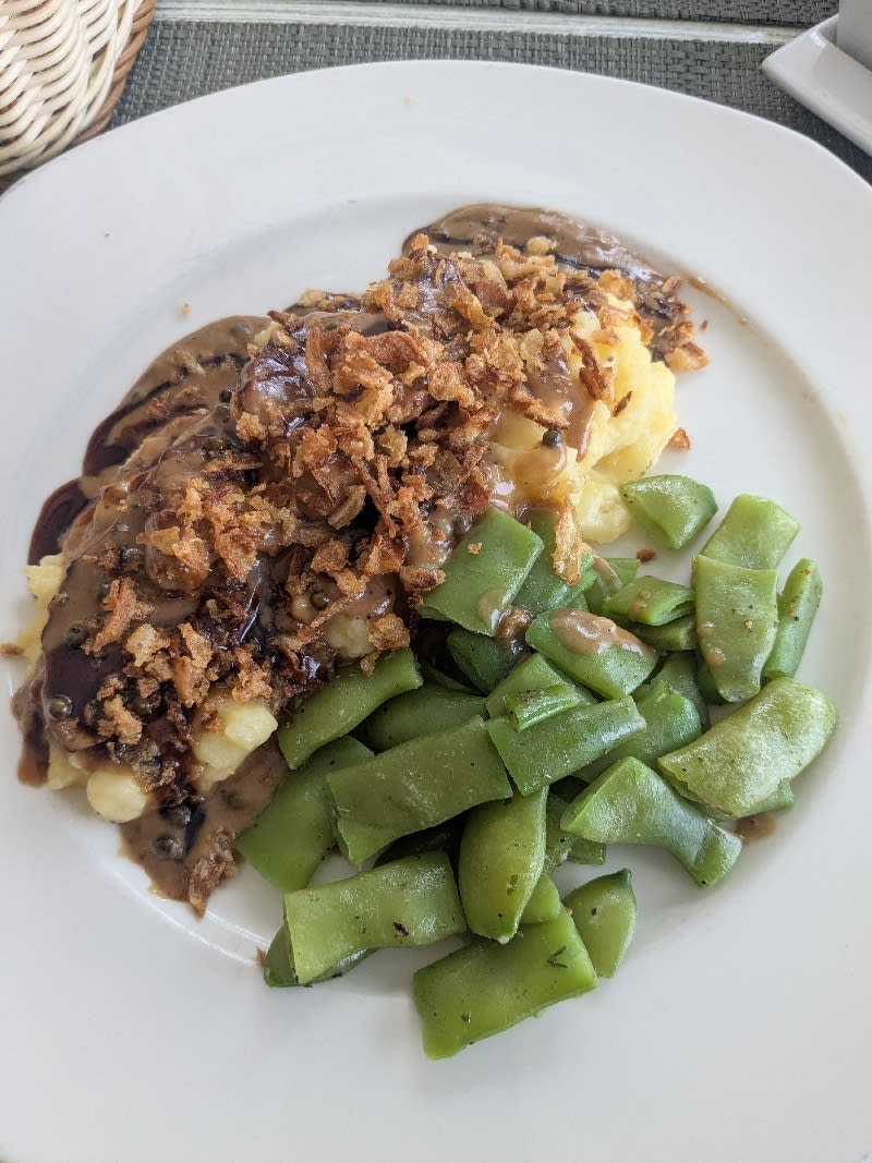 Mediterranean style steak with peppercorn gravy and mashed potatoes