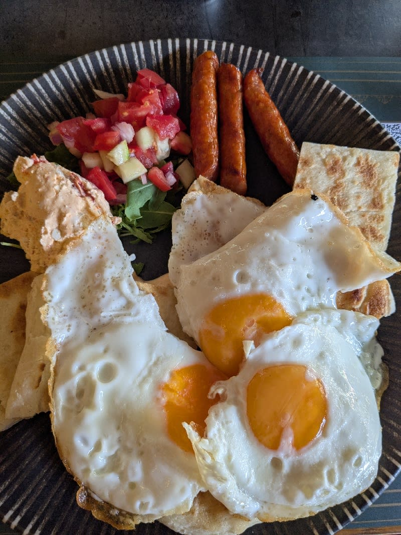 Balkan-style breakfast with fried eggs and spicy sausages