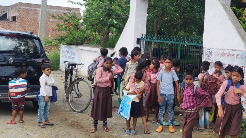 फोटो परिचय- स्कूल का बंद गेट व बाहर टहल रहे स्कूली बच्चे।